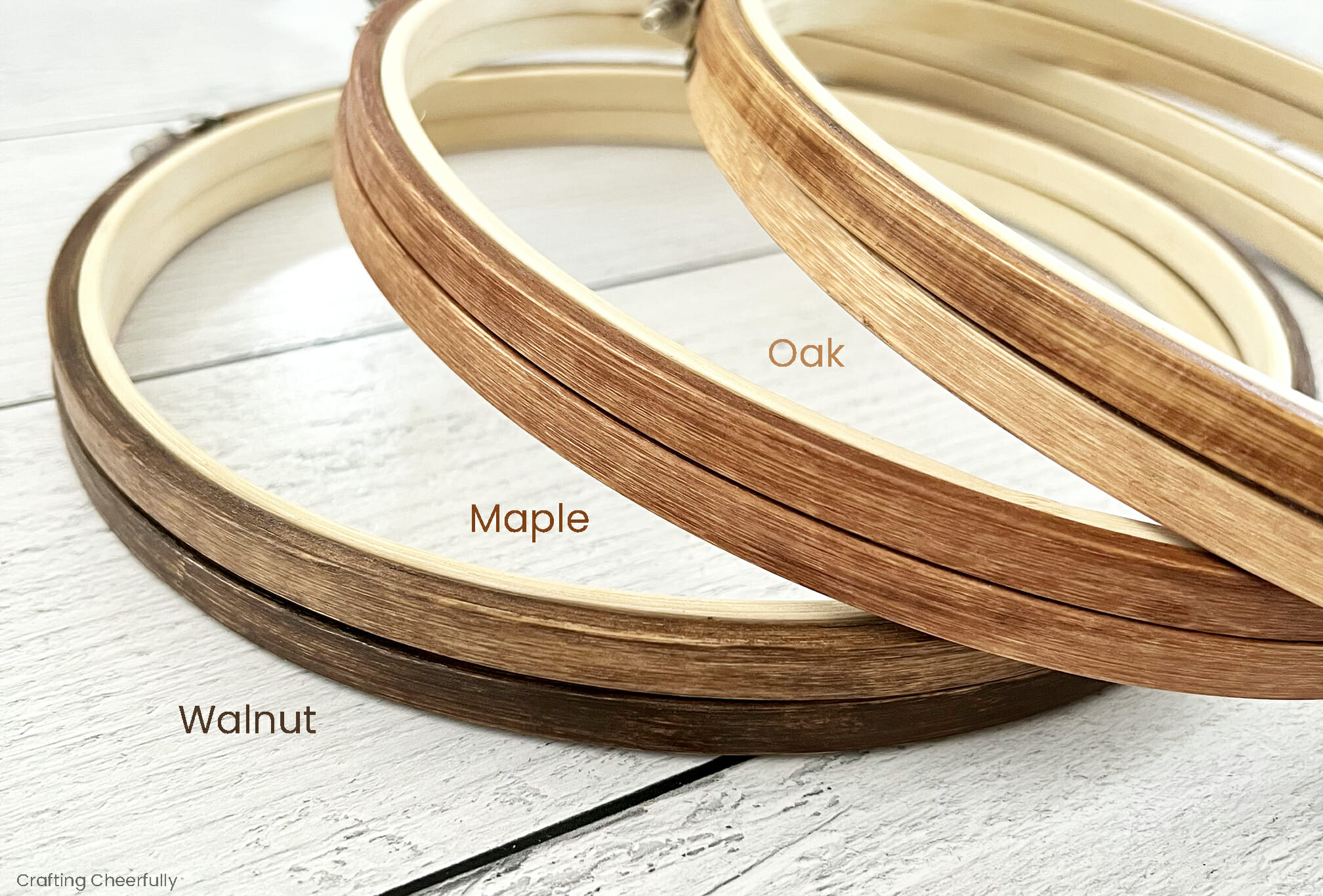Three embroidery hoops that have been stained walnut, maple and oak colors.