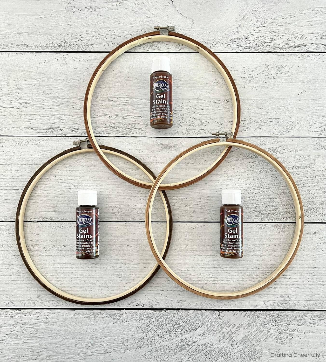 Bottles of wood stain lay inside embroidery hoops.
