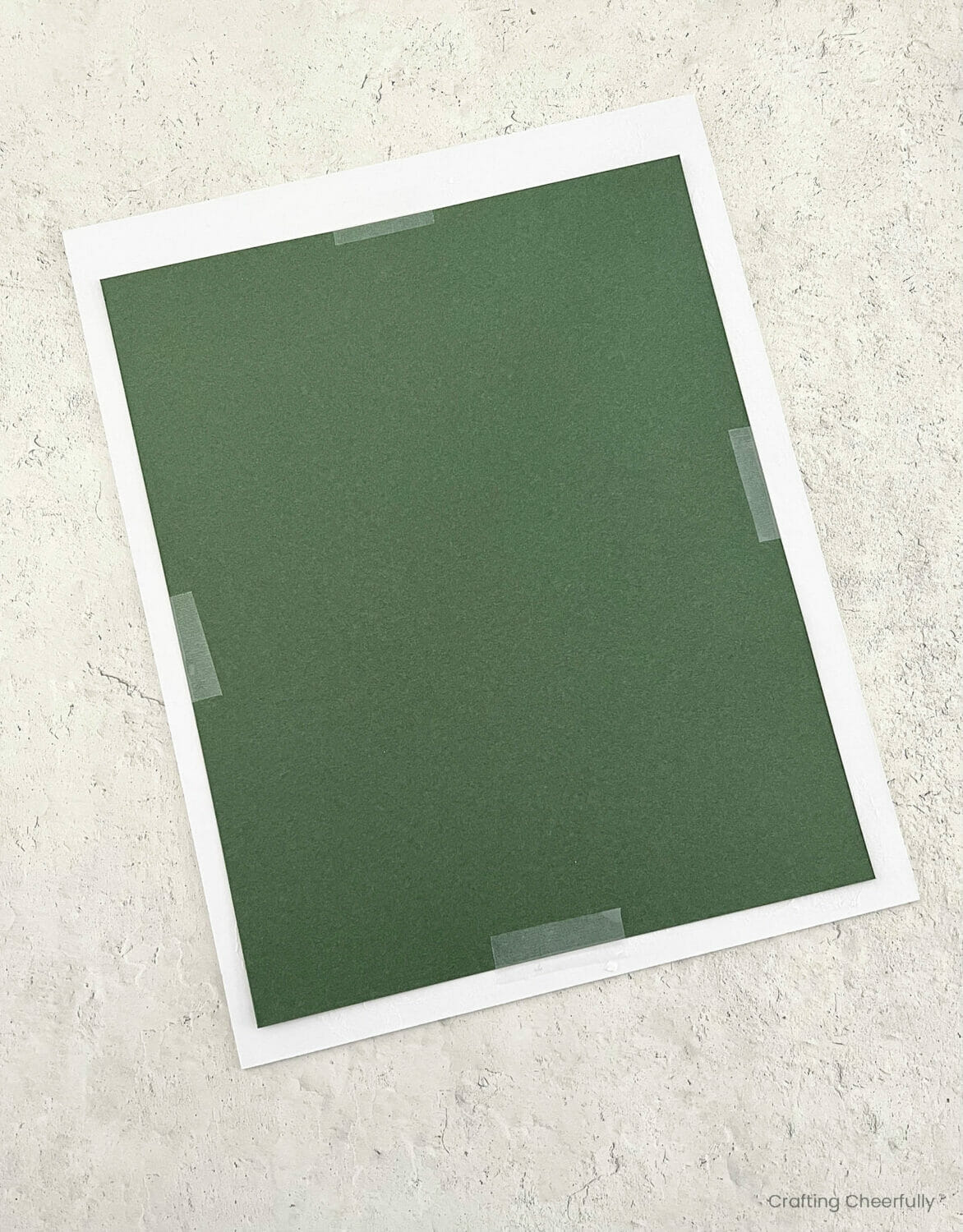 The back of the white mat with the design taped in place.