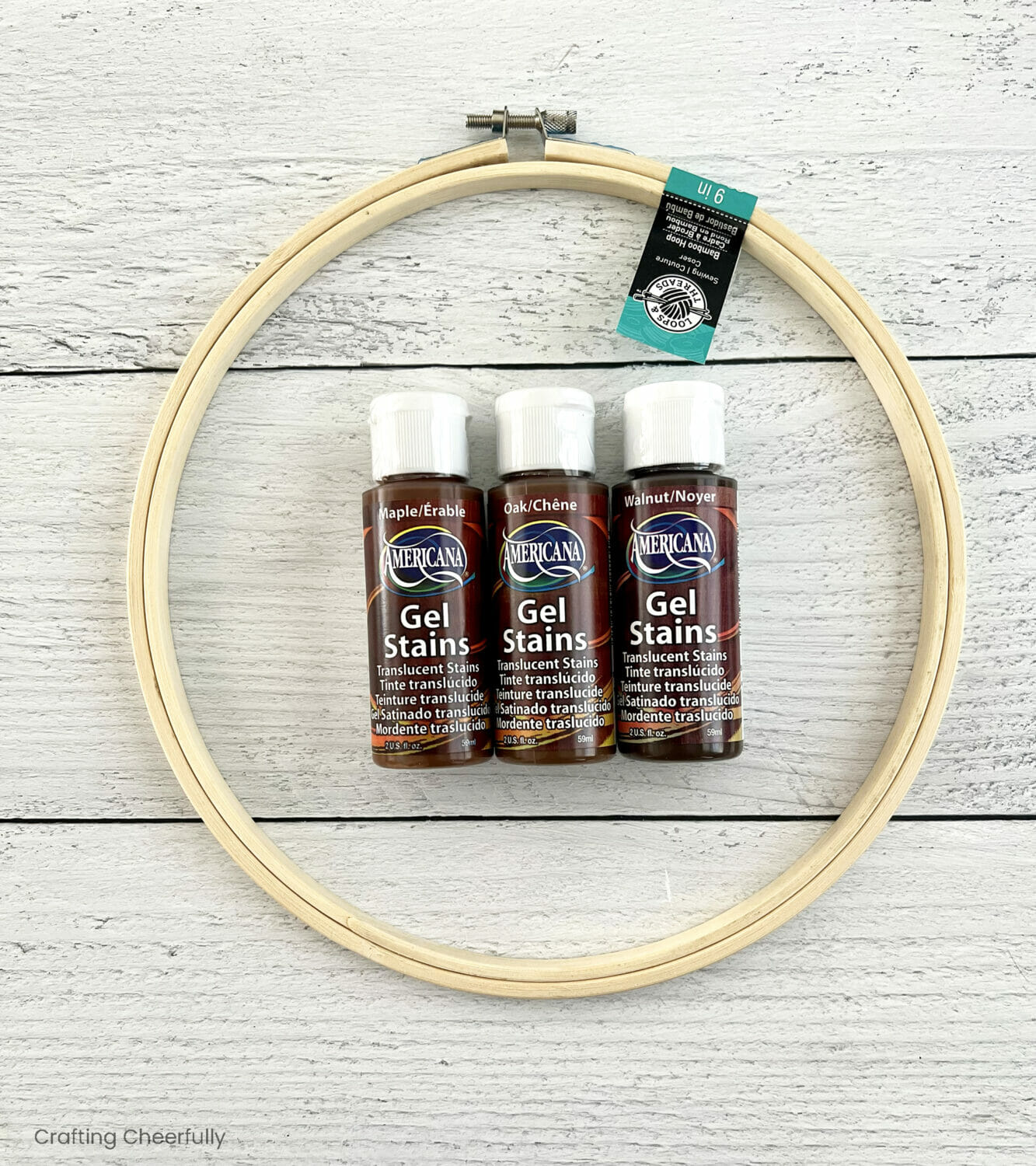 Embroidery hoop with three bottles of gel stain laying in the center.