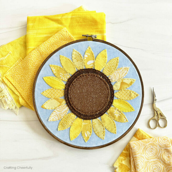 Sunflower embroidery hoop made from yellow and brown scraps of fabric.