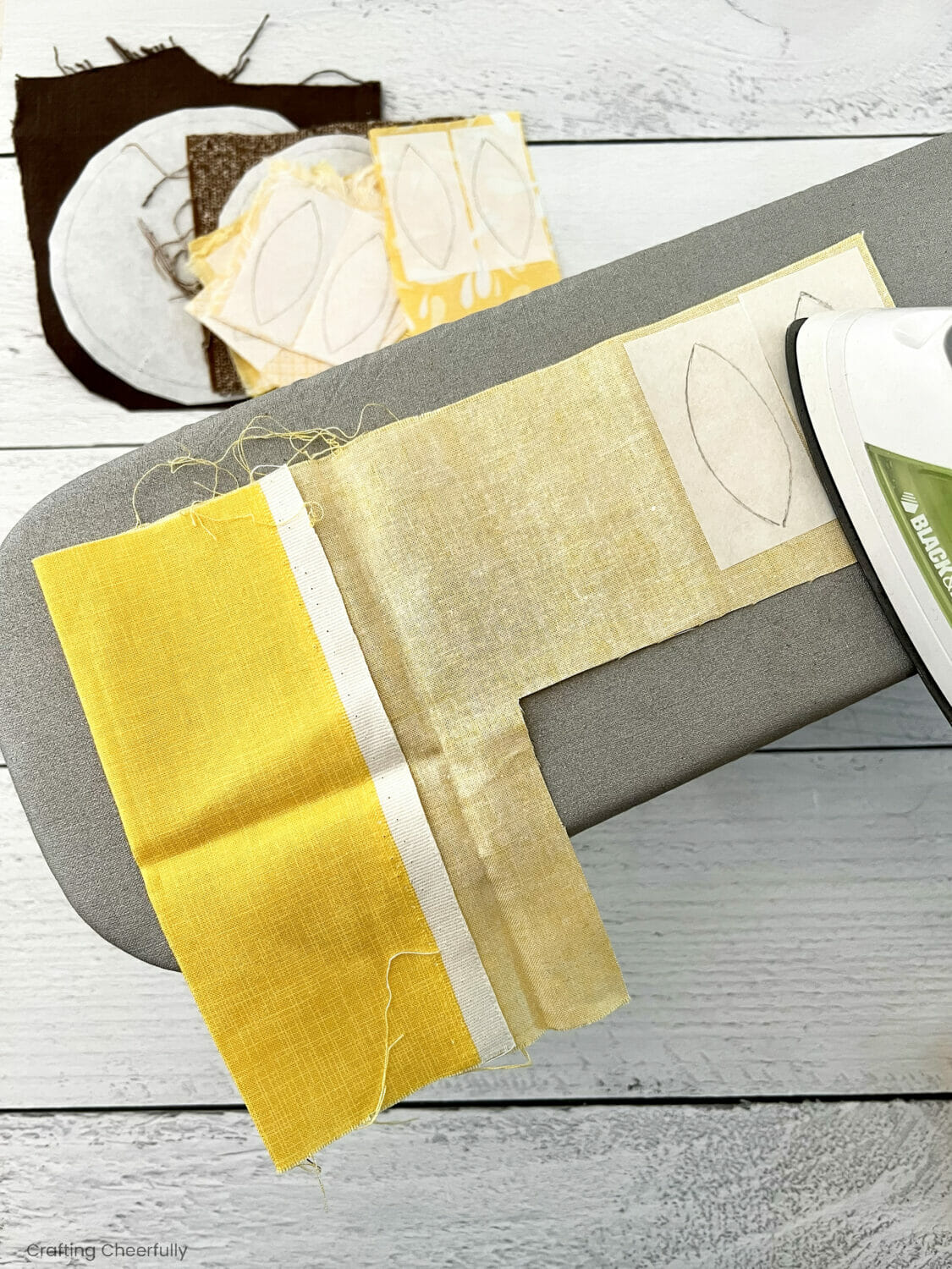 Interfacing petals are ironed to the top of a yellow scrap of fabric.