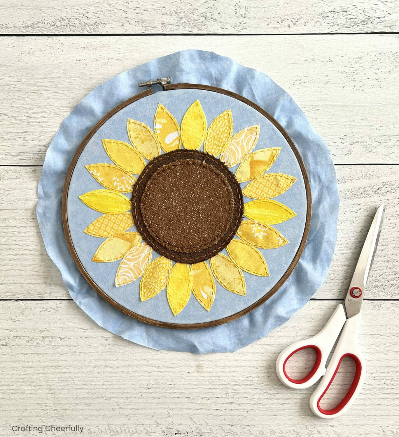 The blue fabric in the hoop is trimmed to about 1". 