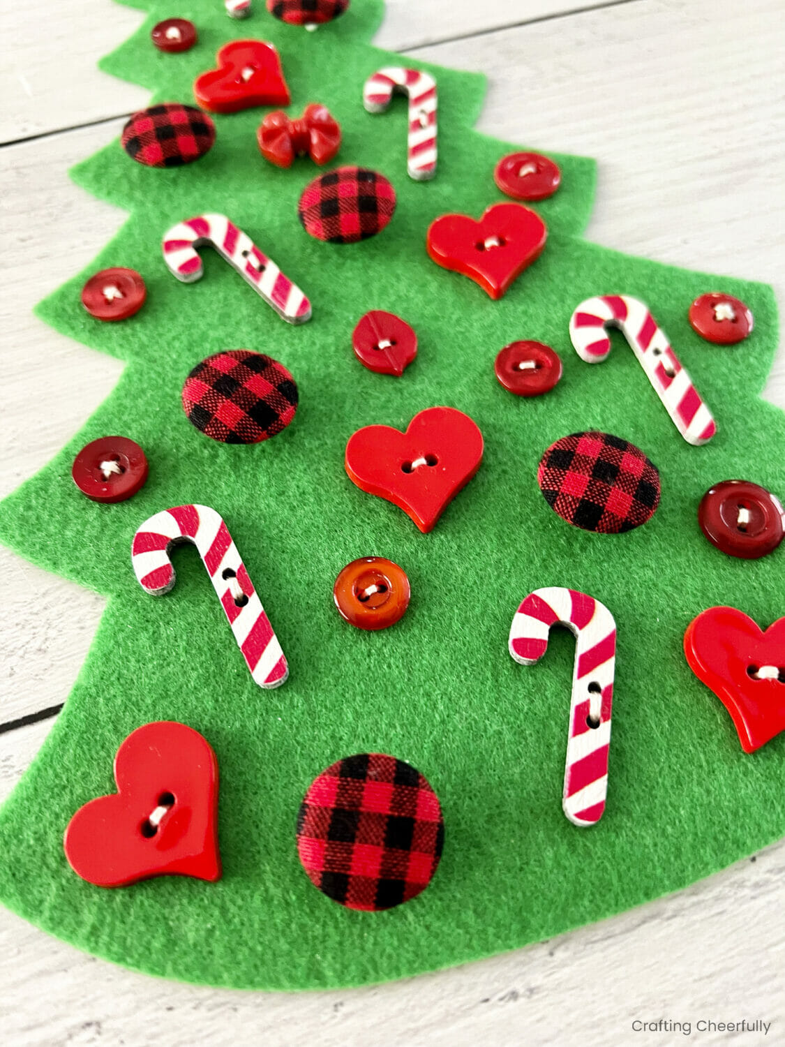 Buttons stitched on the green felt tree.