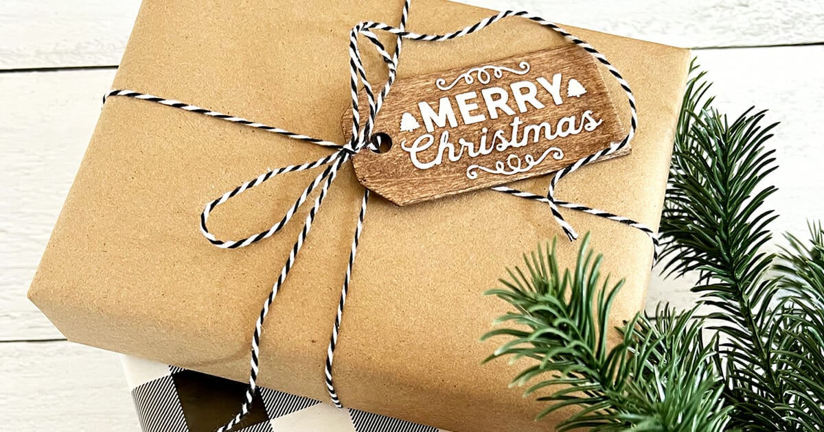 Stained Wood Holiday Gift Tags A kraft paper parcel tied with black and white twine and a small stained wood tag reading Merry Christmas