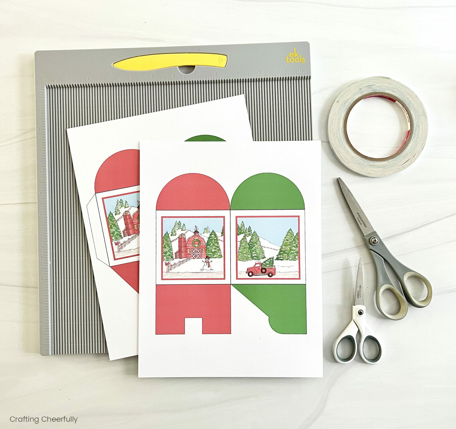 Farmhouse printable boxes lay next to a scoring board, scissors and double-sided tape.