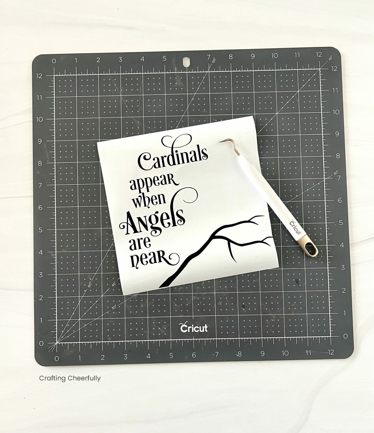 Text cut from black vinyl is weeded on a black cutting mat.