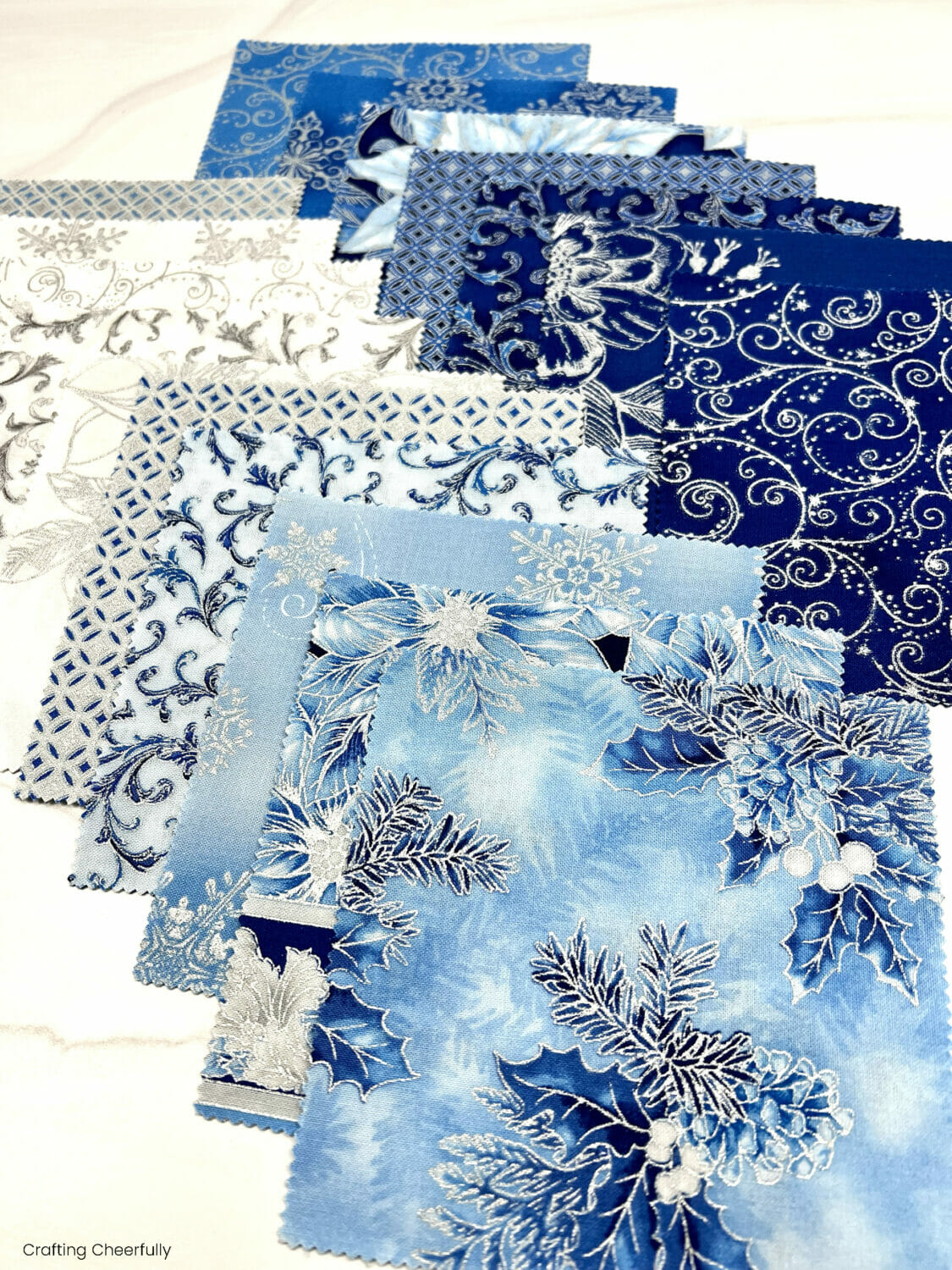 Beautiful charm pack fabrics laid out on a table.