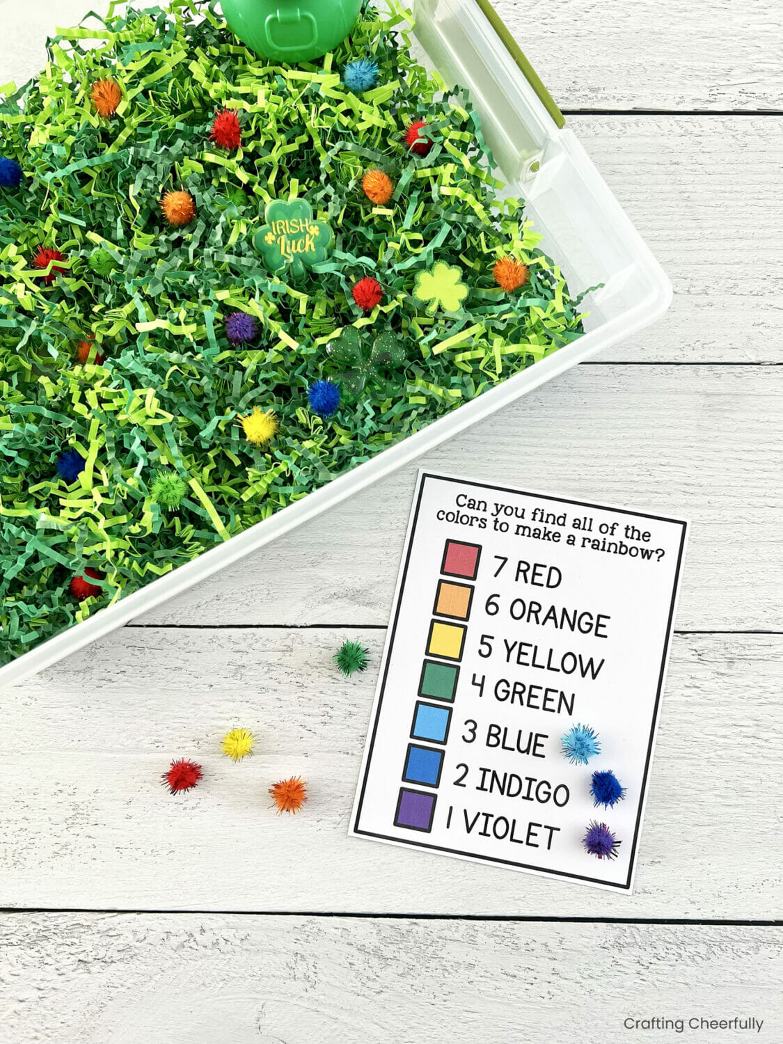 Rainbow checklist lays next to the St. Patrick's sensory bin.