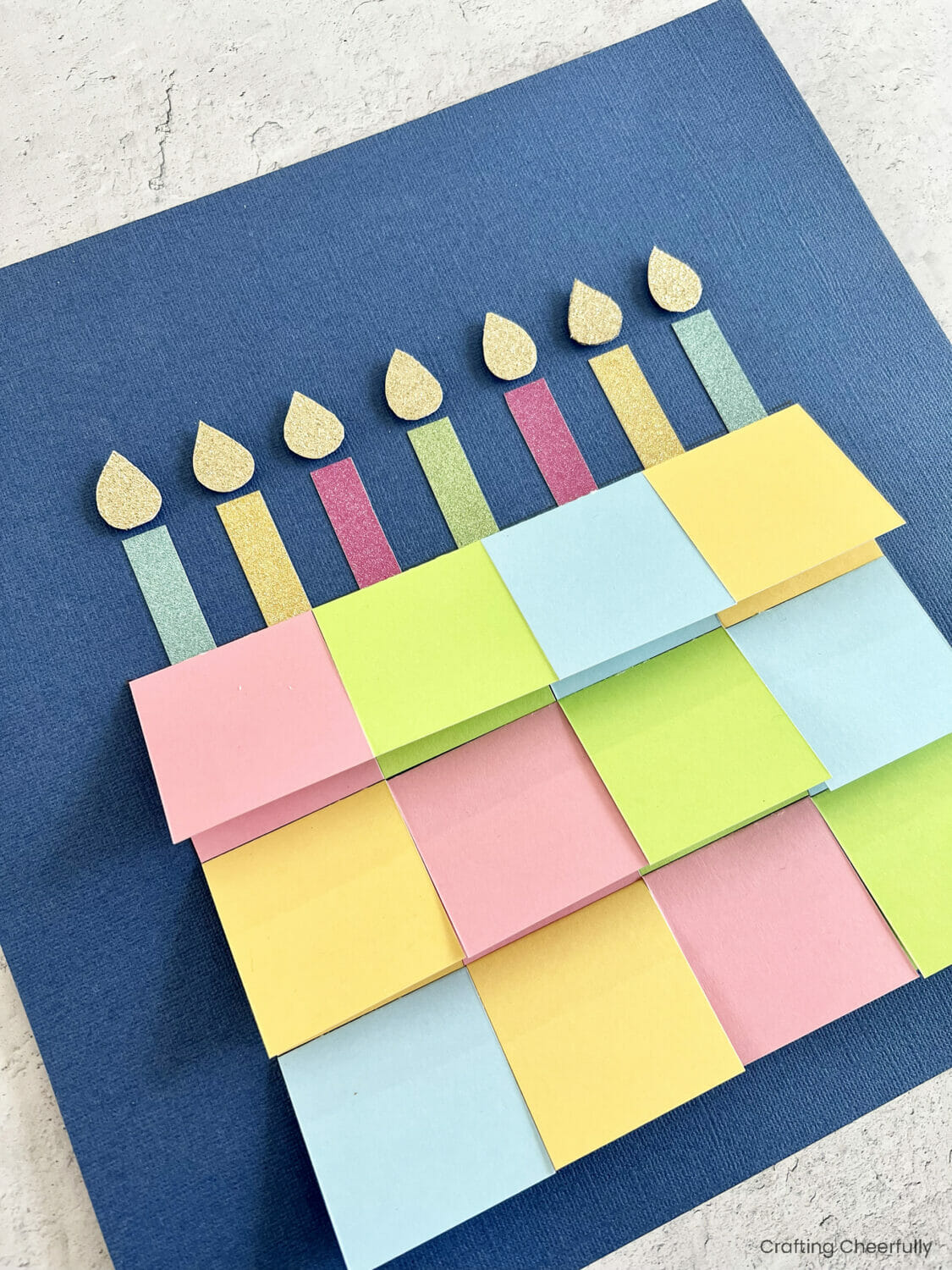 Paper candles with gold glitter paper flames are added to the top of the cake.