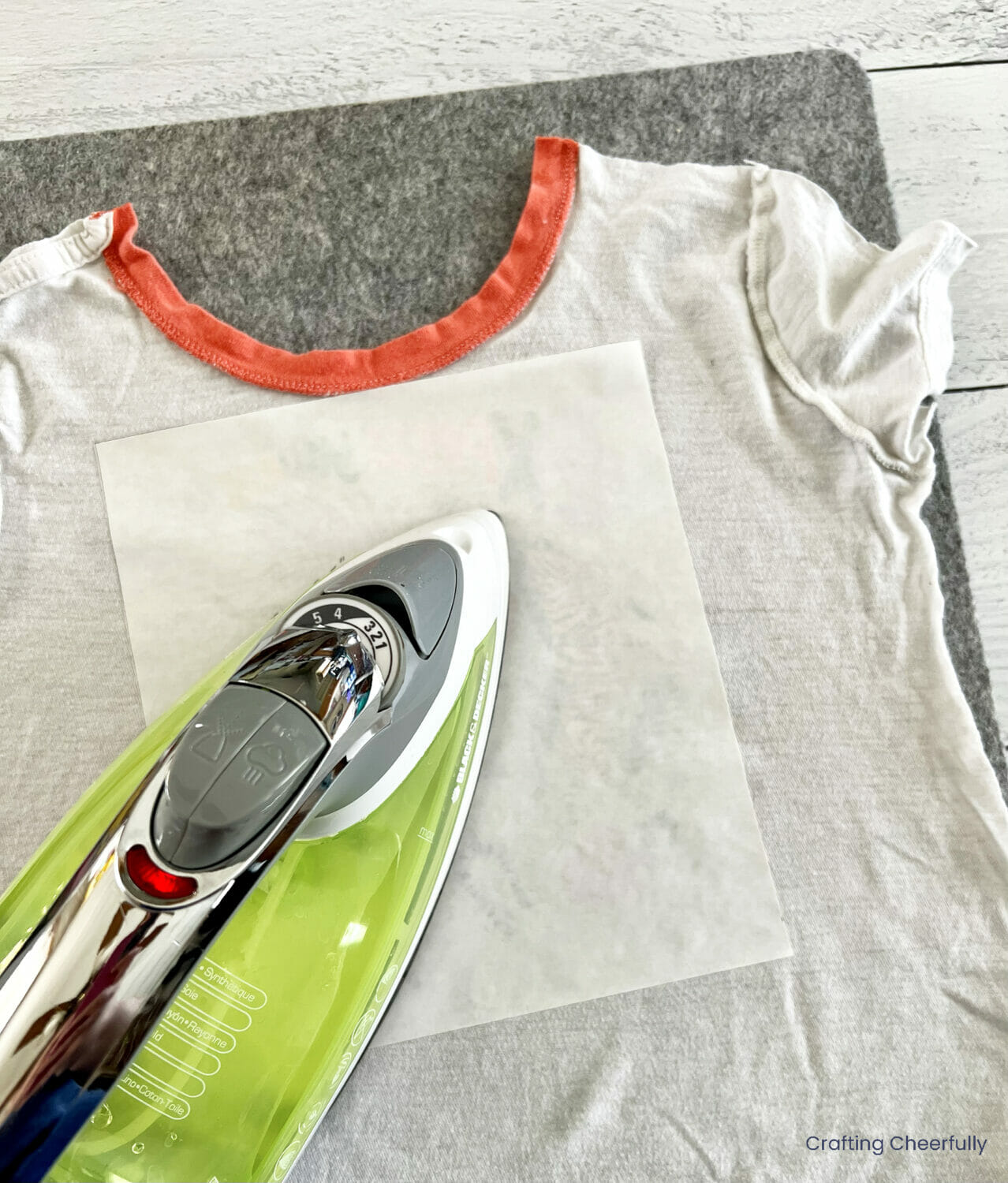 Fusible web is ironed to the back of the t-shirt over the design.