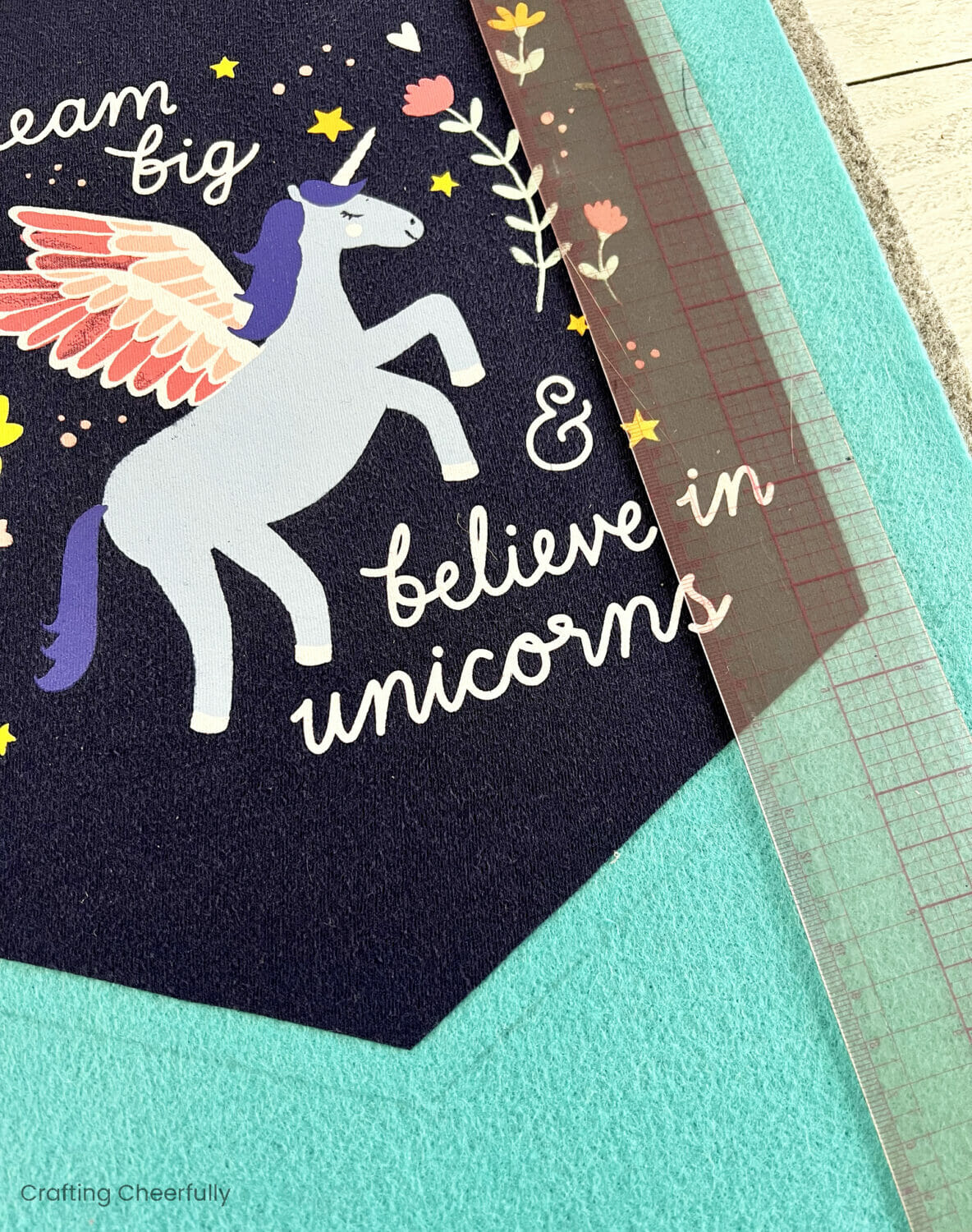 A ruler marks the teal felt around the banner.
