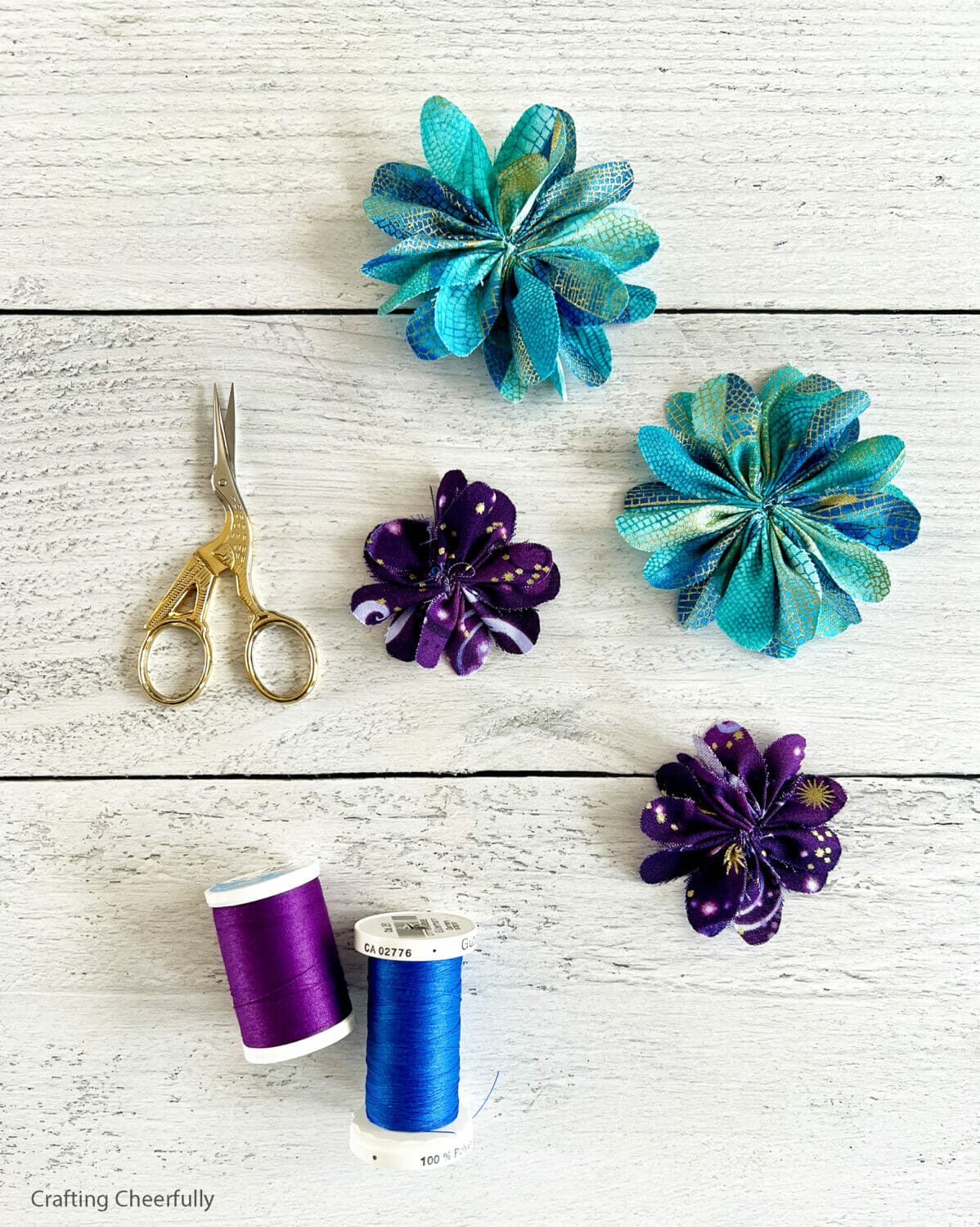 Fabric flowers; 2 large teal flowers and 2 small purple flowers.