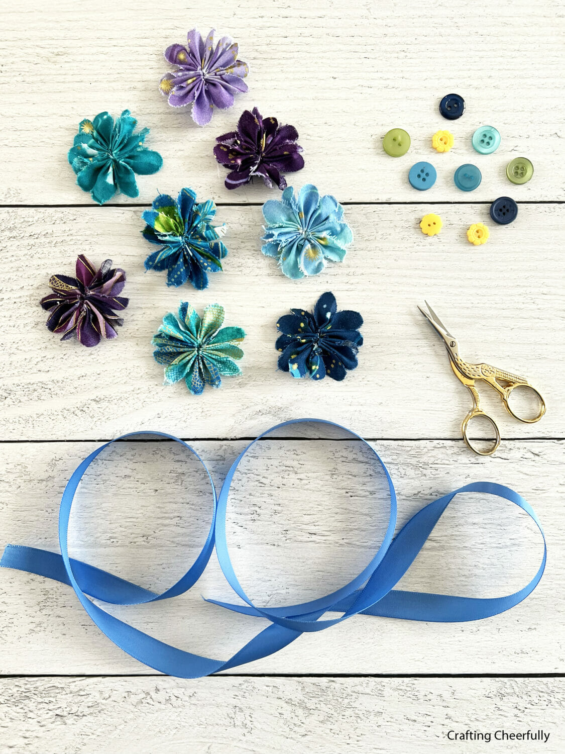 Fabric flowers, buttons and blue ribbon.