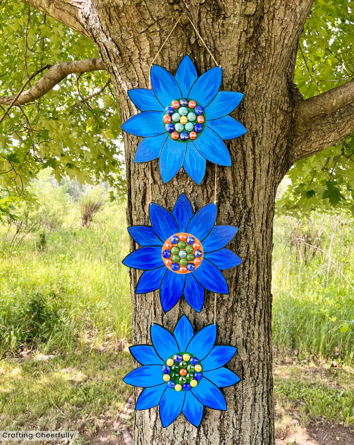 Blue floral hanging garden art in a tree.