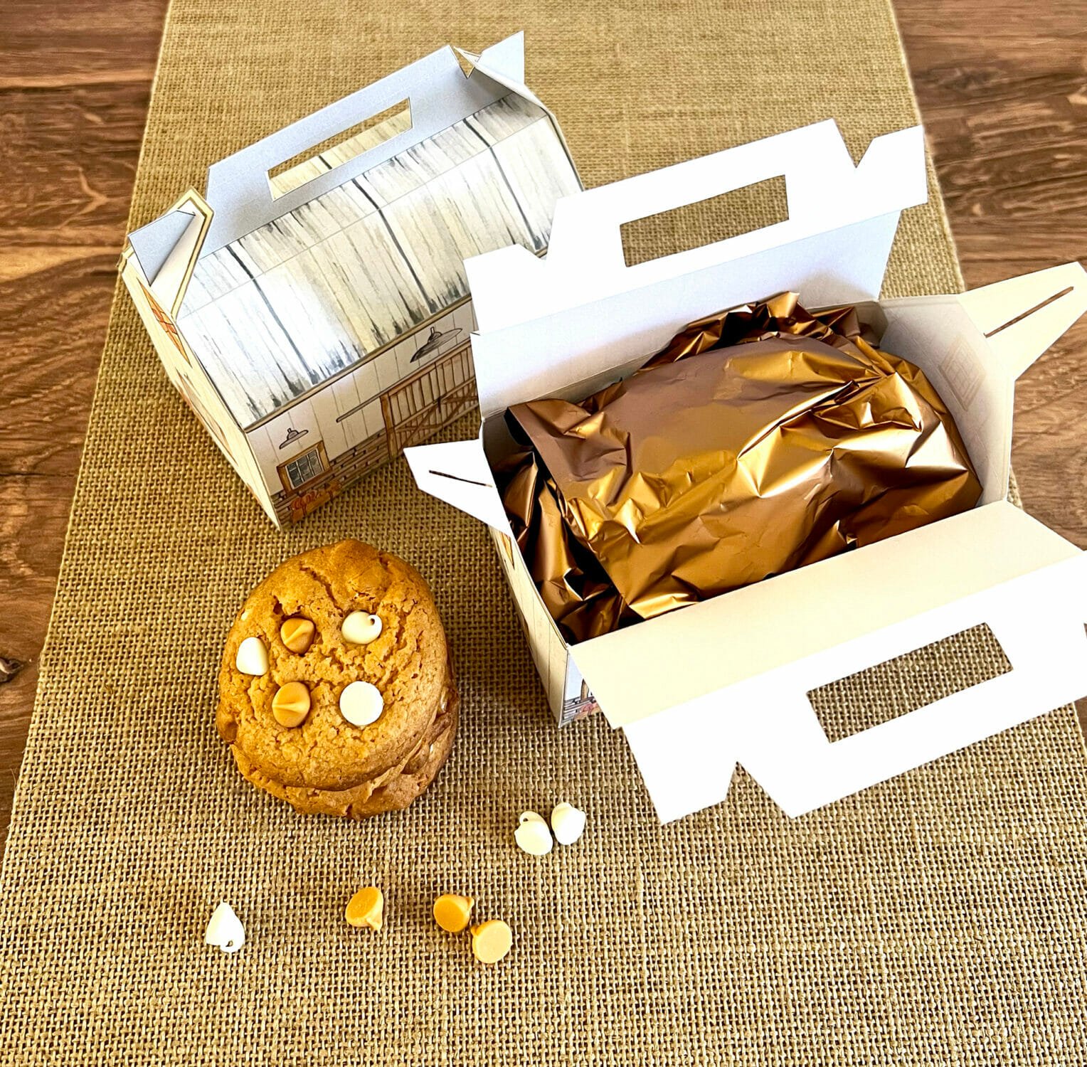 Two farm treat boxes with one open showing cookies wrapped in gold foil.
