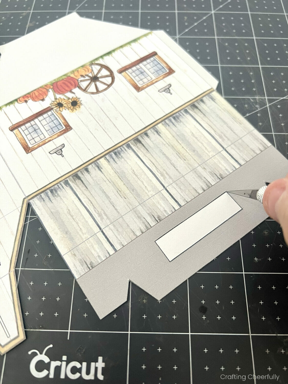 A rectangle in the handle of the treat box is cut out with a craft knife.