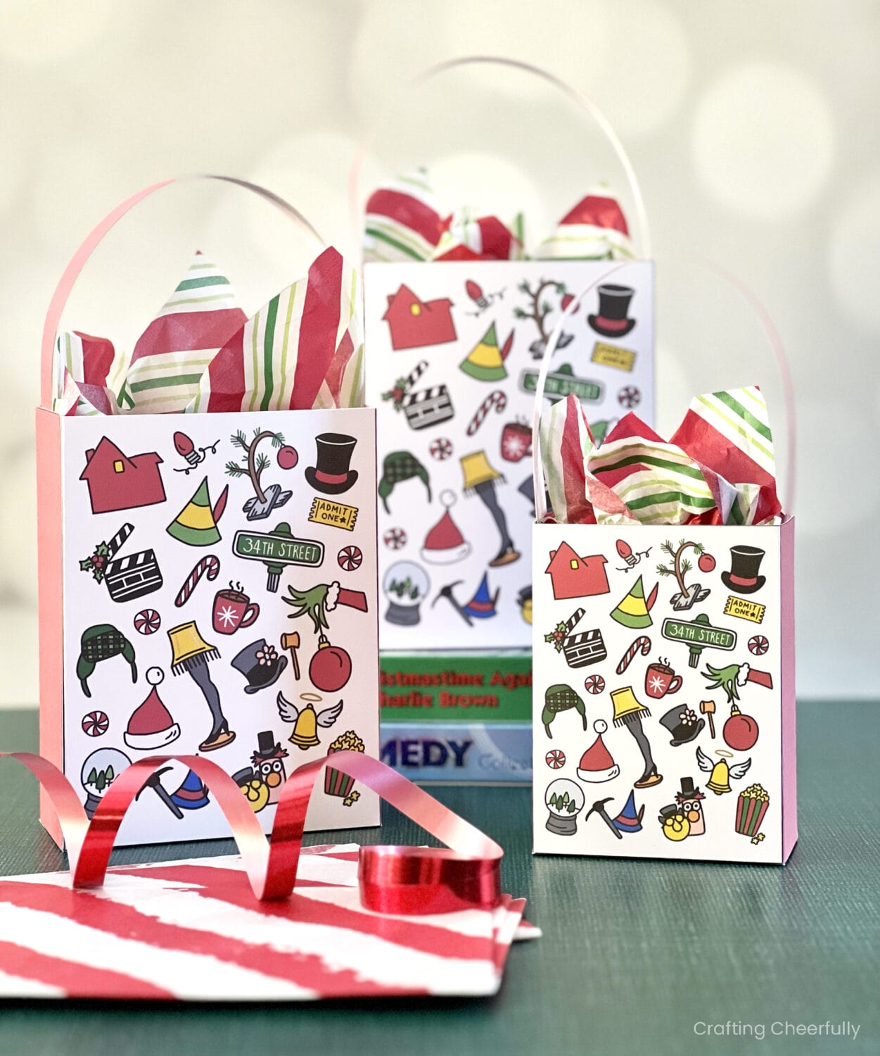 Three Christmas movie treat bags are grouped together and sitting on a green surface.