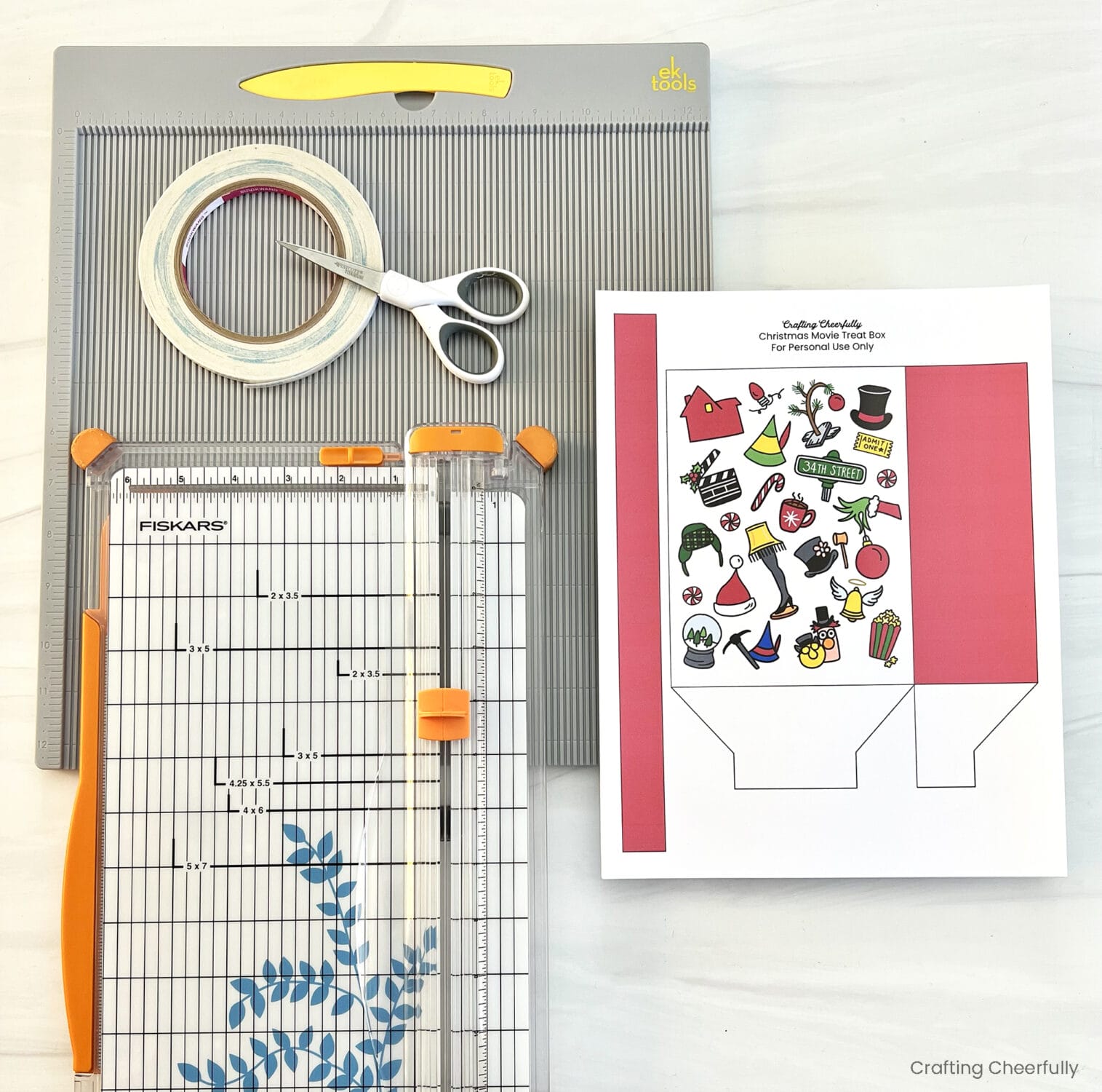 Supplies for the treat bag including a paper trimmer, scoring board, and printable treat bag.