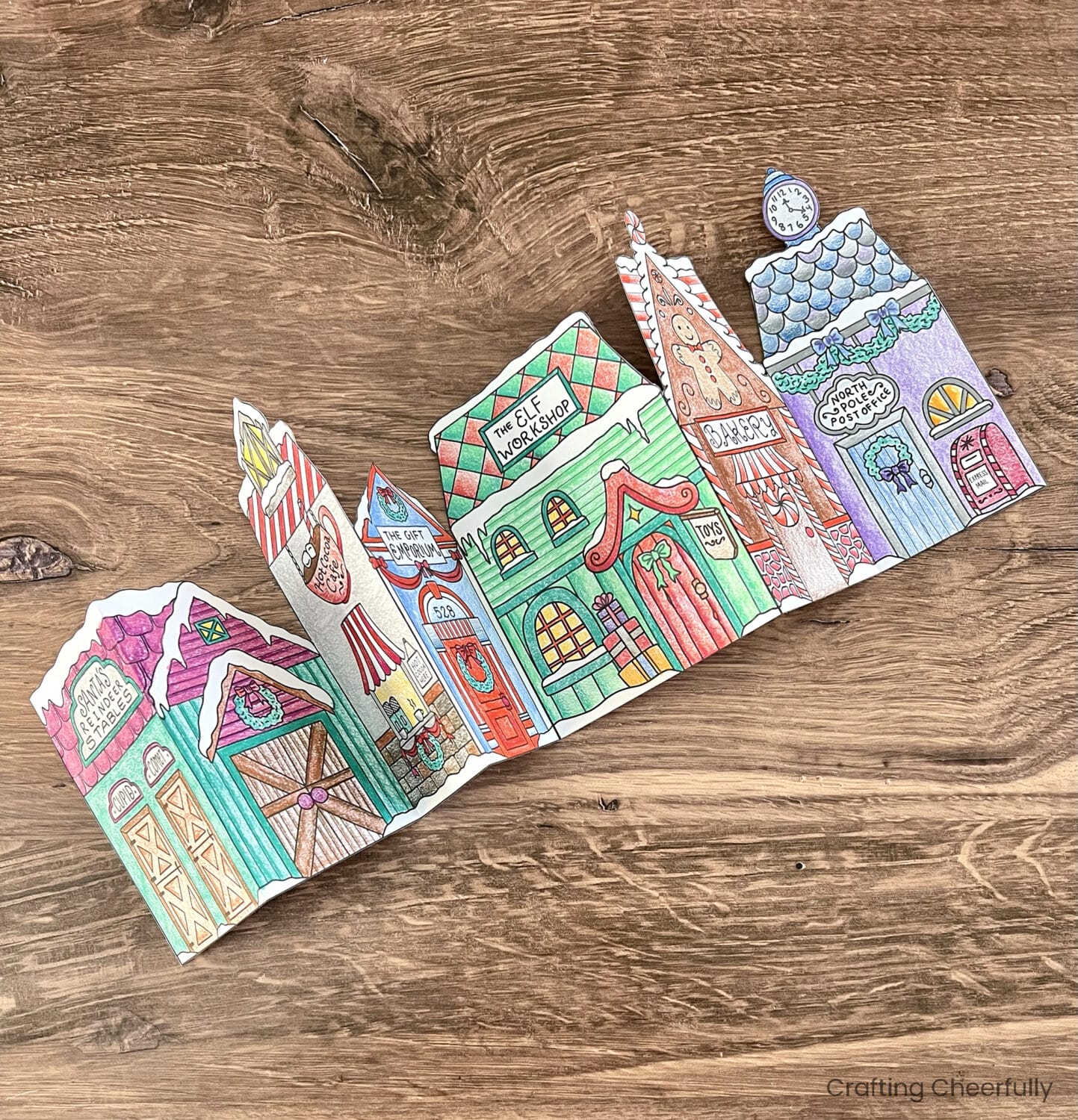 The Christmas village pieces are taped together to form a long city.