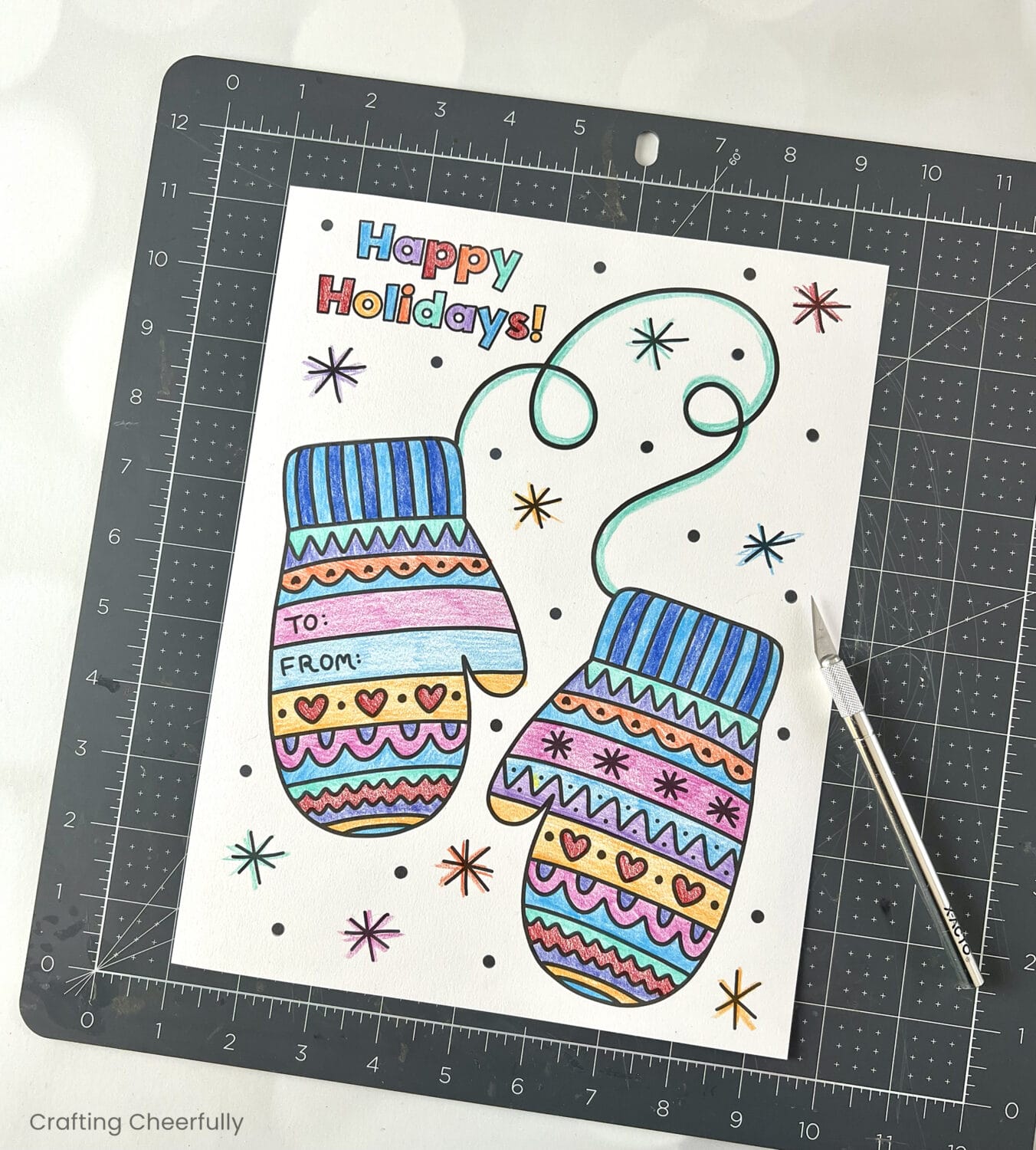 The mitten coloring page lays next to a craft knife.