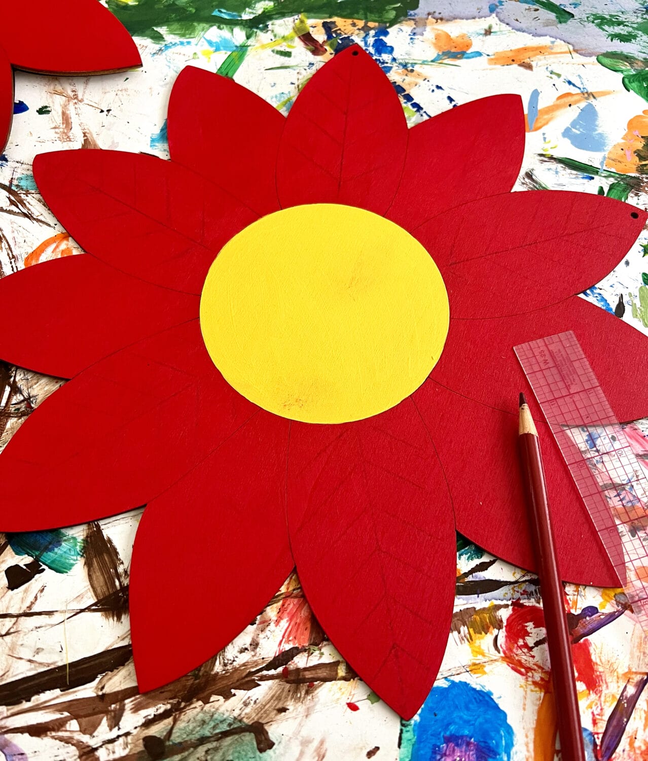 A pencil and ruler are used to draw vein lines on every other petal.