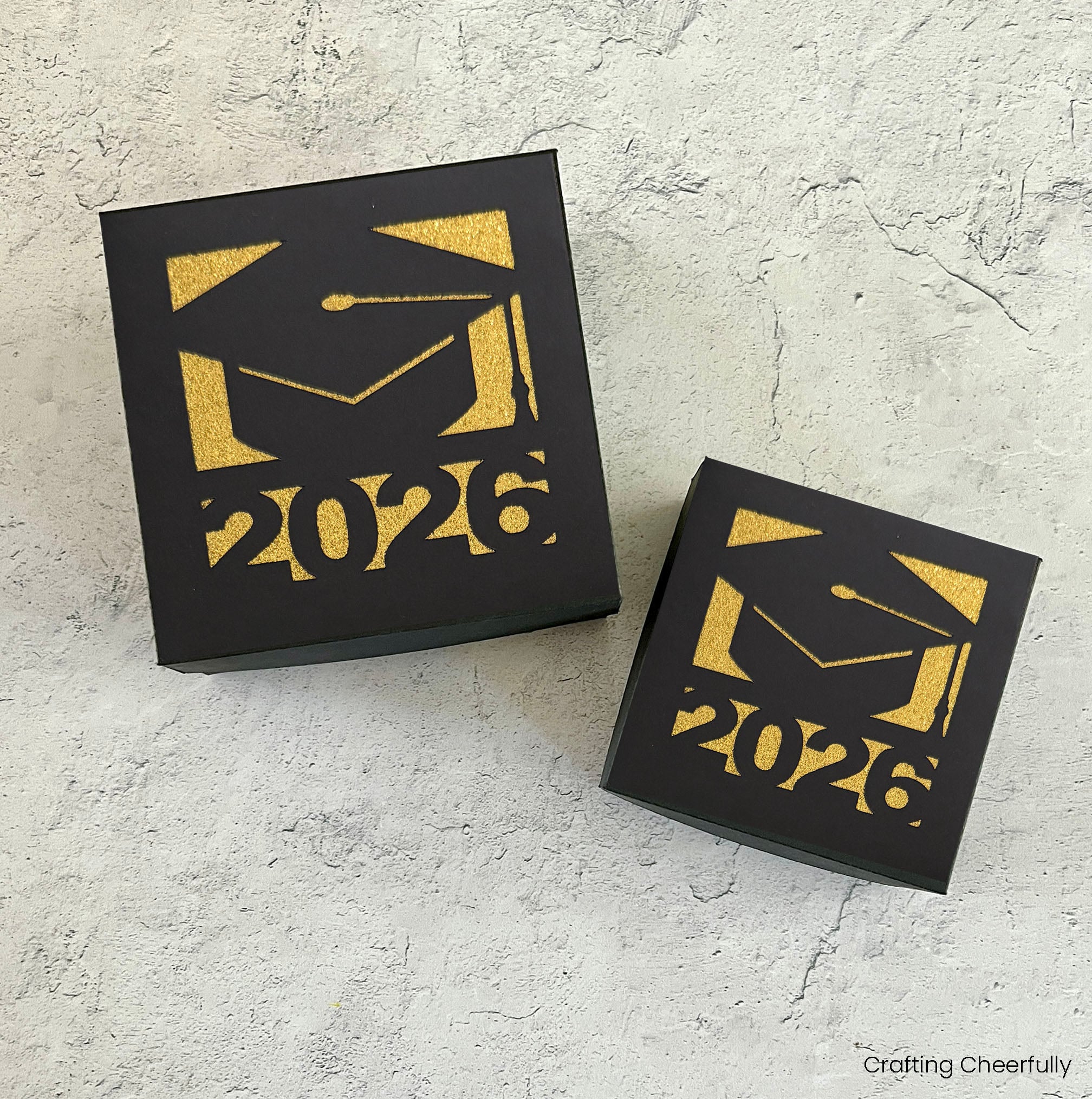 Two square graduation boxes with a grad cap and the year 2026 on it.