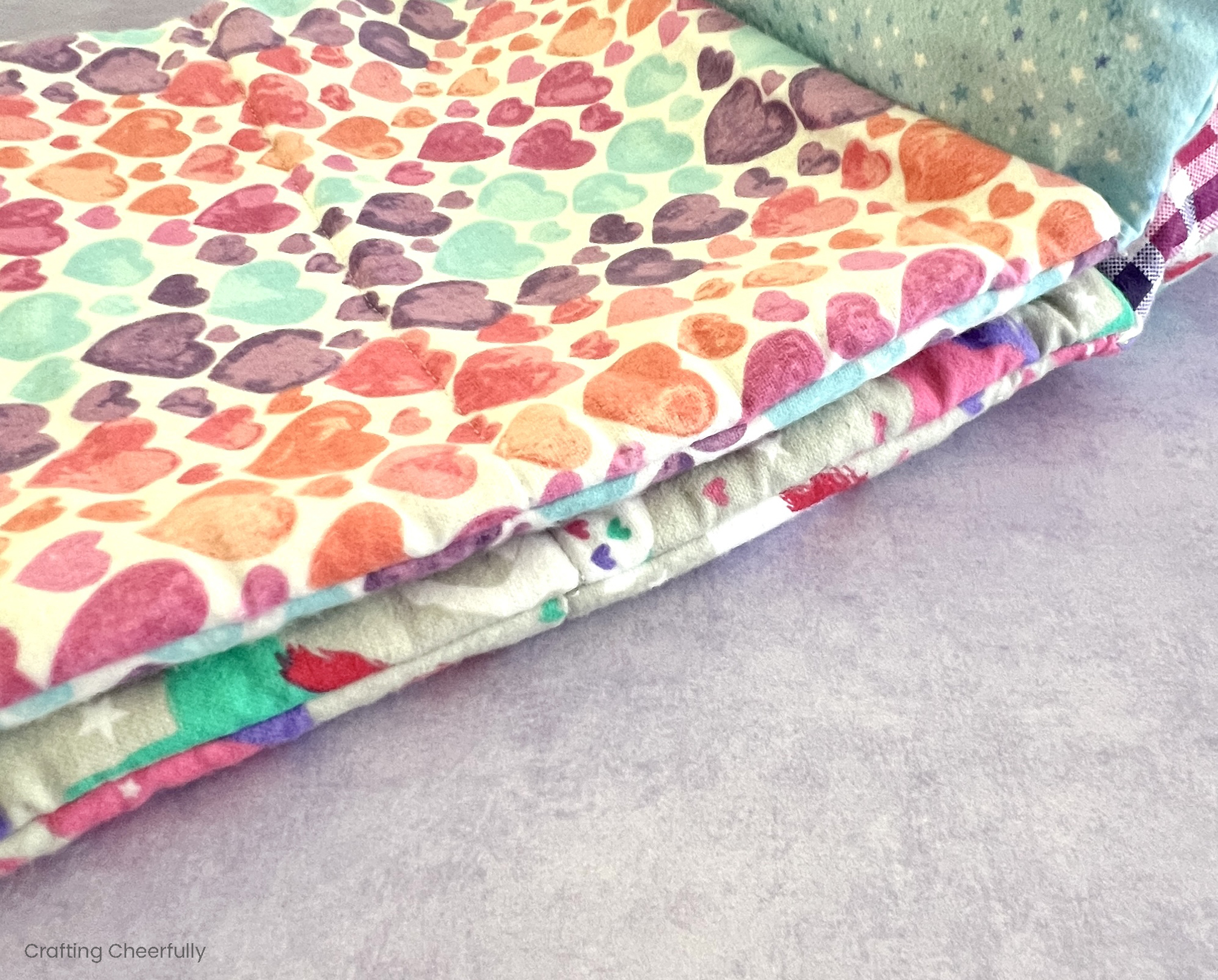 Two sleeping bags laying on top of one another; the top layer is thinner made from interfacing and the bottom is thicker made from fleece.
