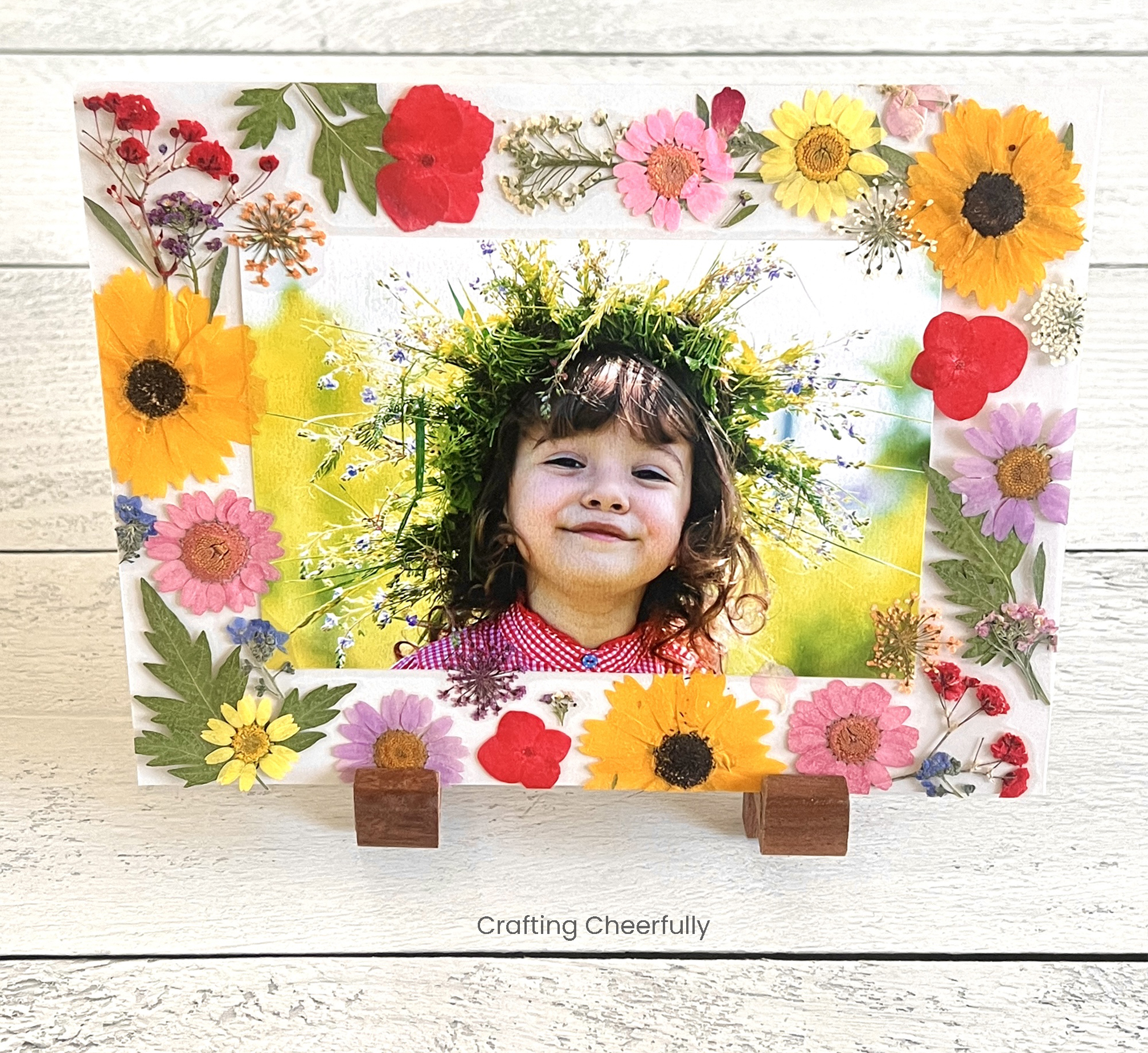 Pressed flower frame sits in a wooden easel.