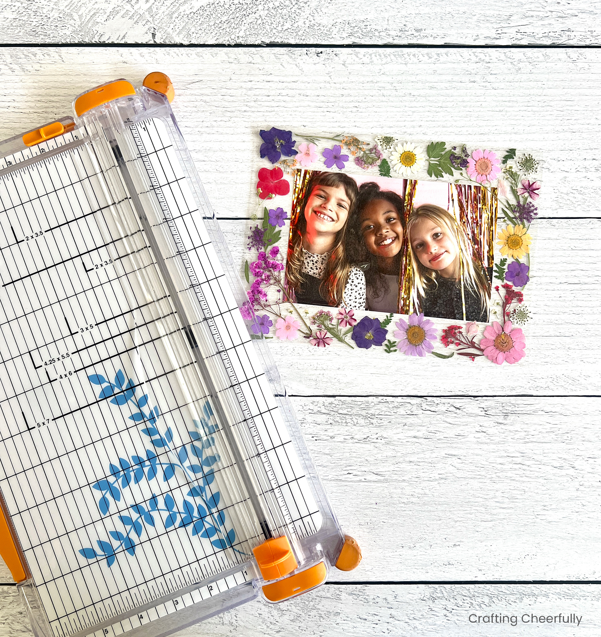 The cut out photo frame lays next to the paper trimmer.