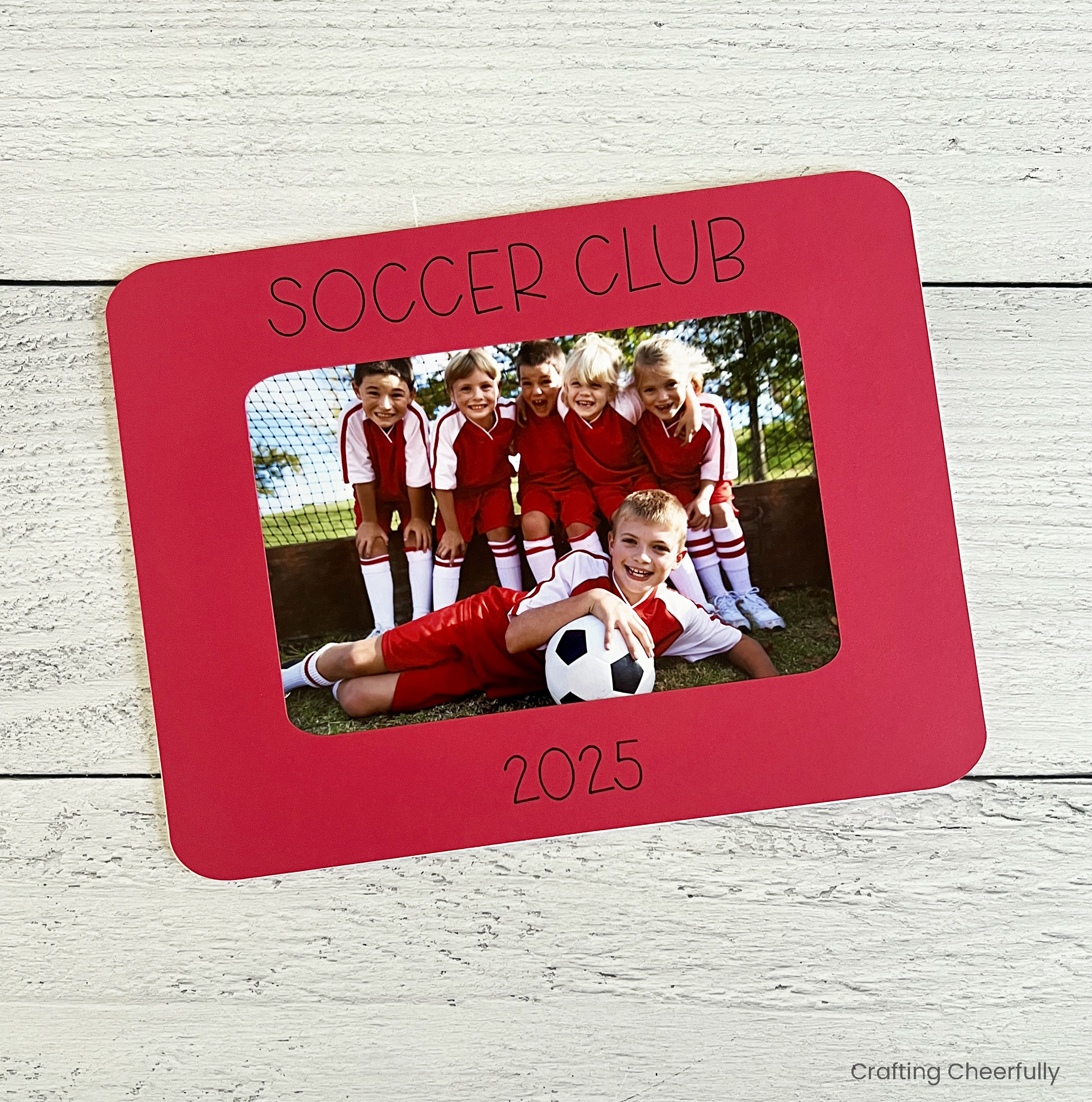 Red paper frame reads Soccer Club with a picture of a soccer team inside.