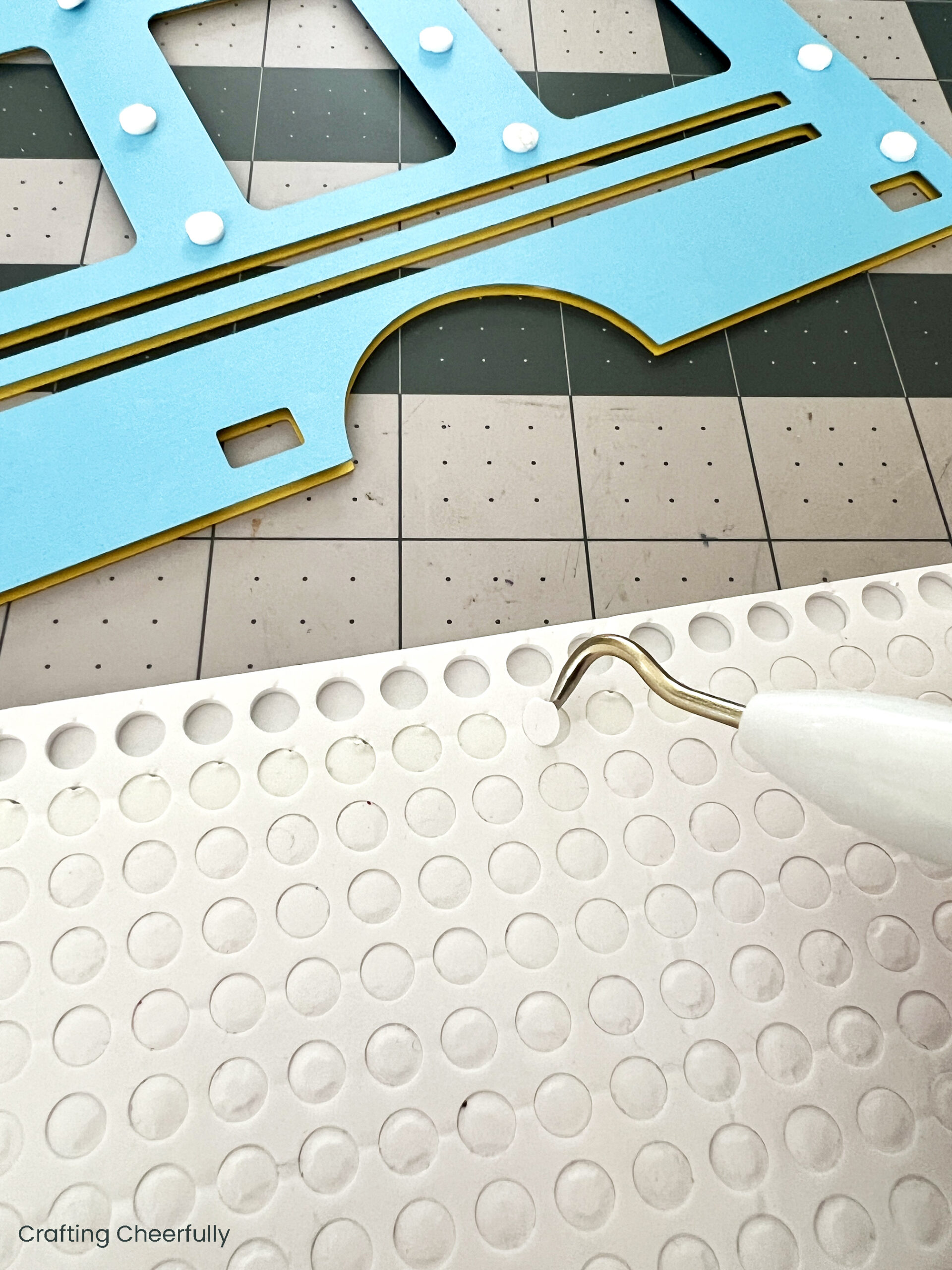 Foam dots are applied to the back of the blue layer of paper.