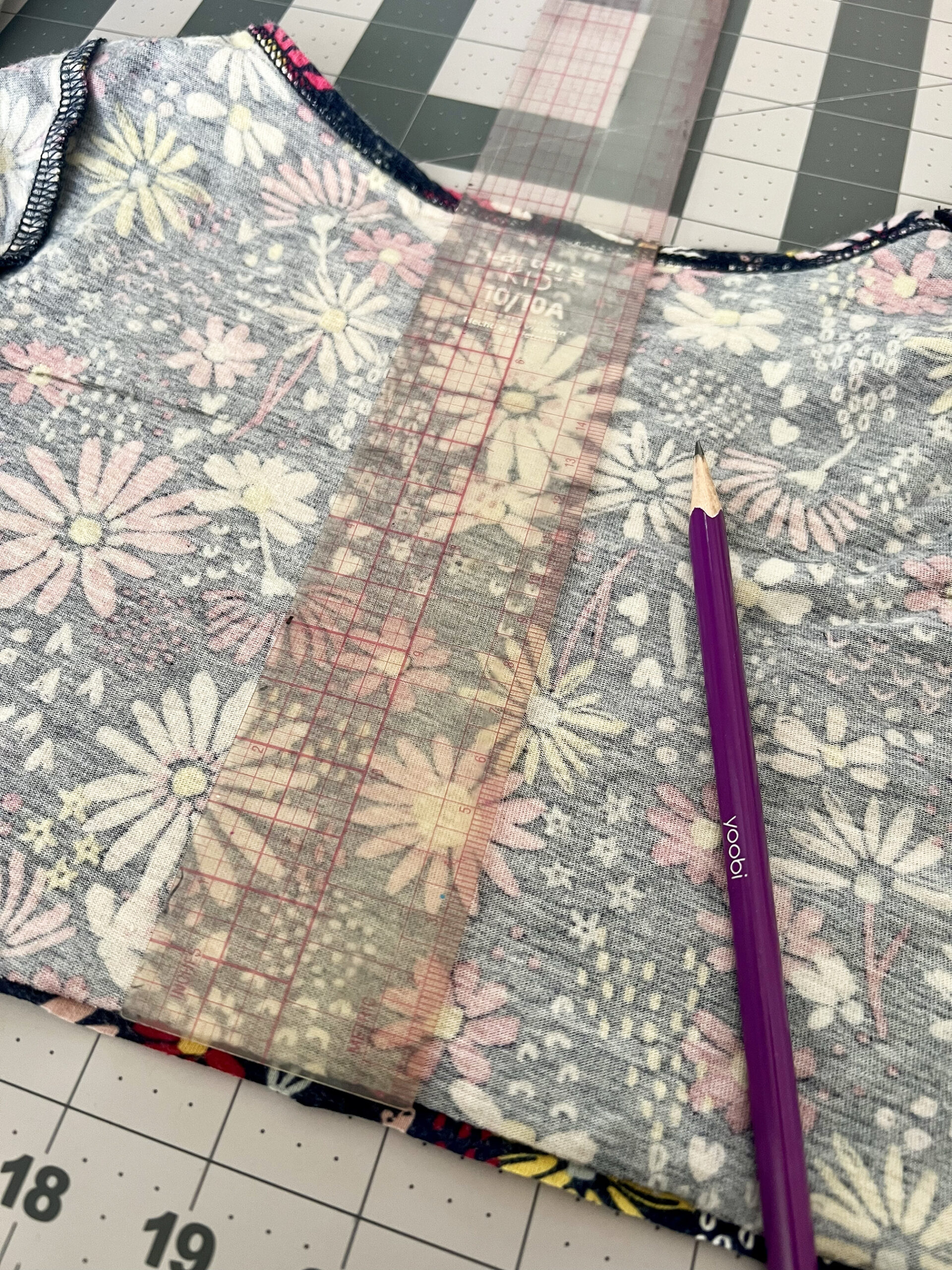 A ruler is use to measure a rectangle from the bodice of the girl's dress.