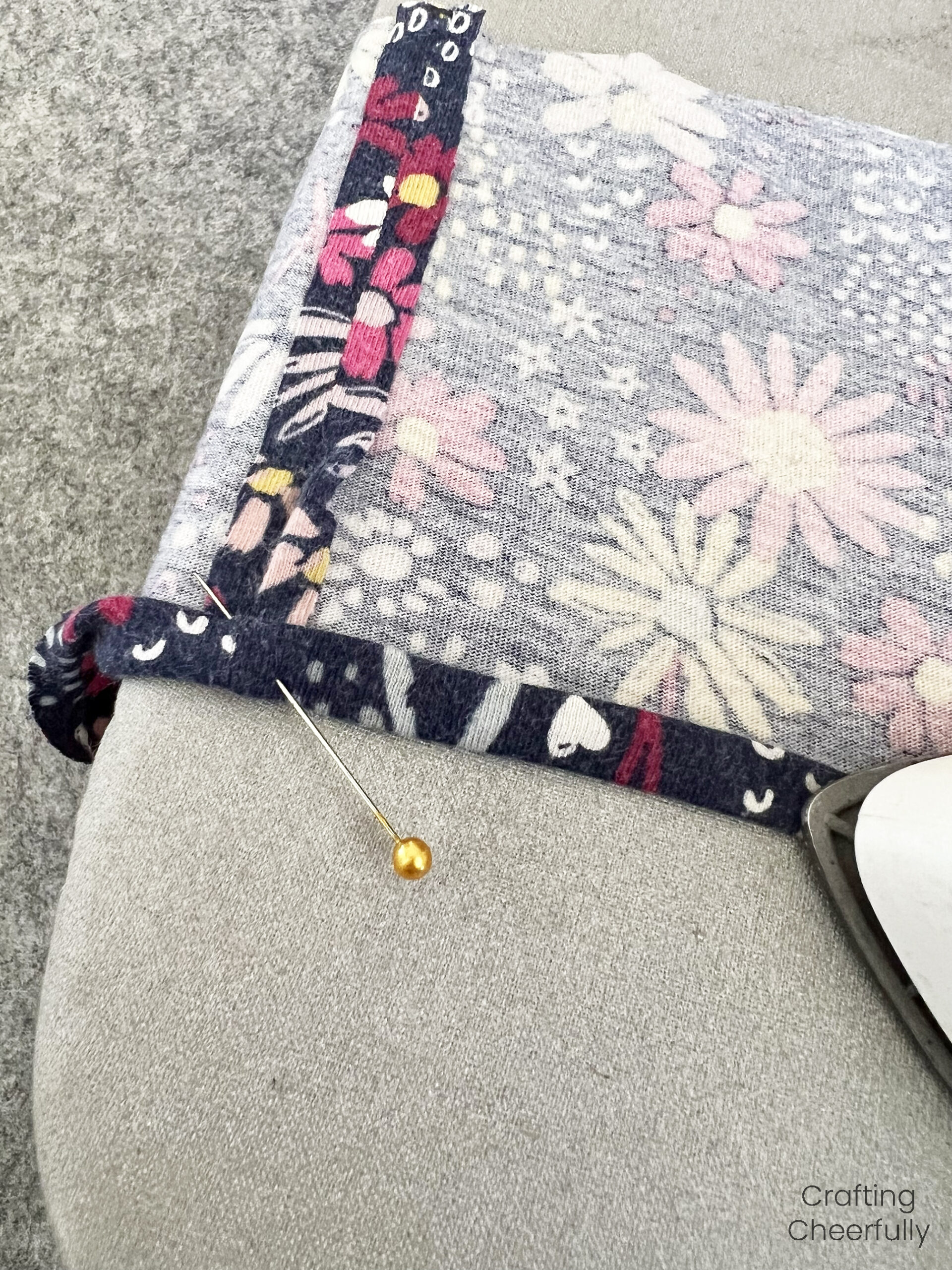 A tiny hem is formed along the bottom of the doll skirt and pressed and pinned in place.