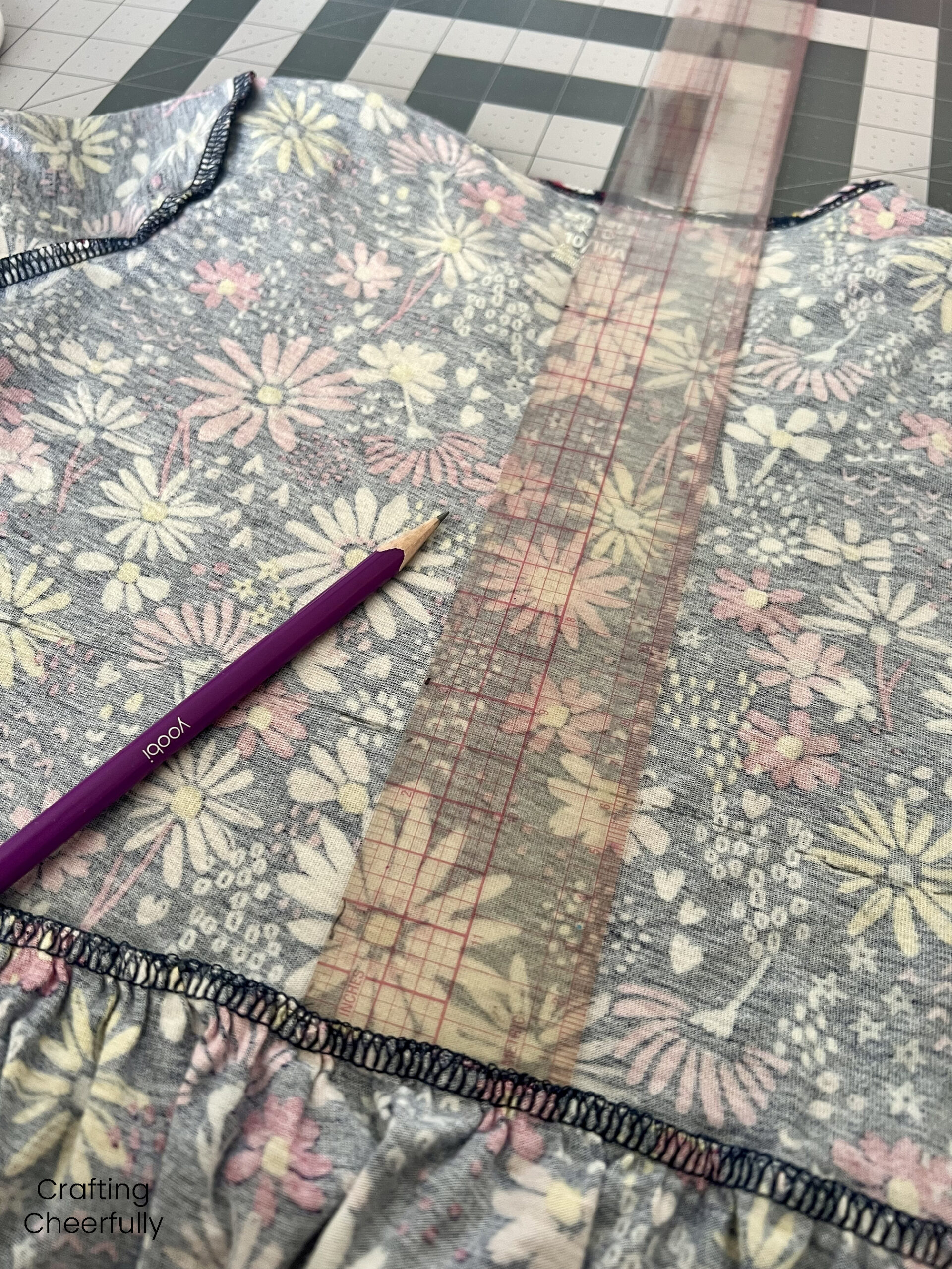 A ruler is used to mark wear to cut a girl's dress into two pieces.