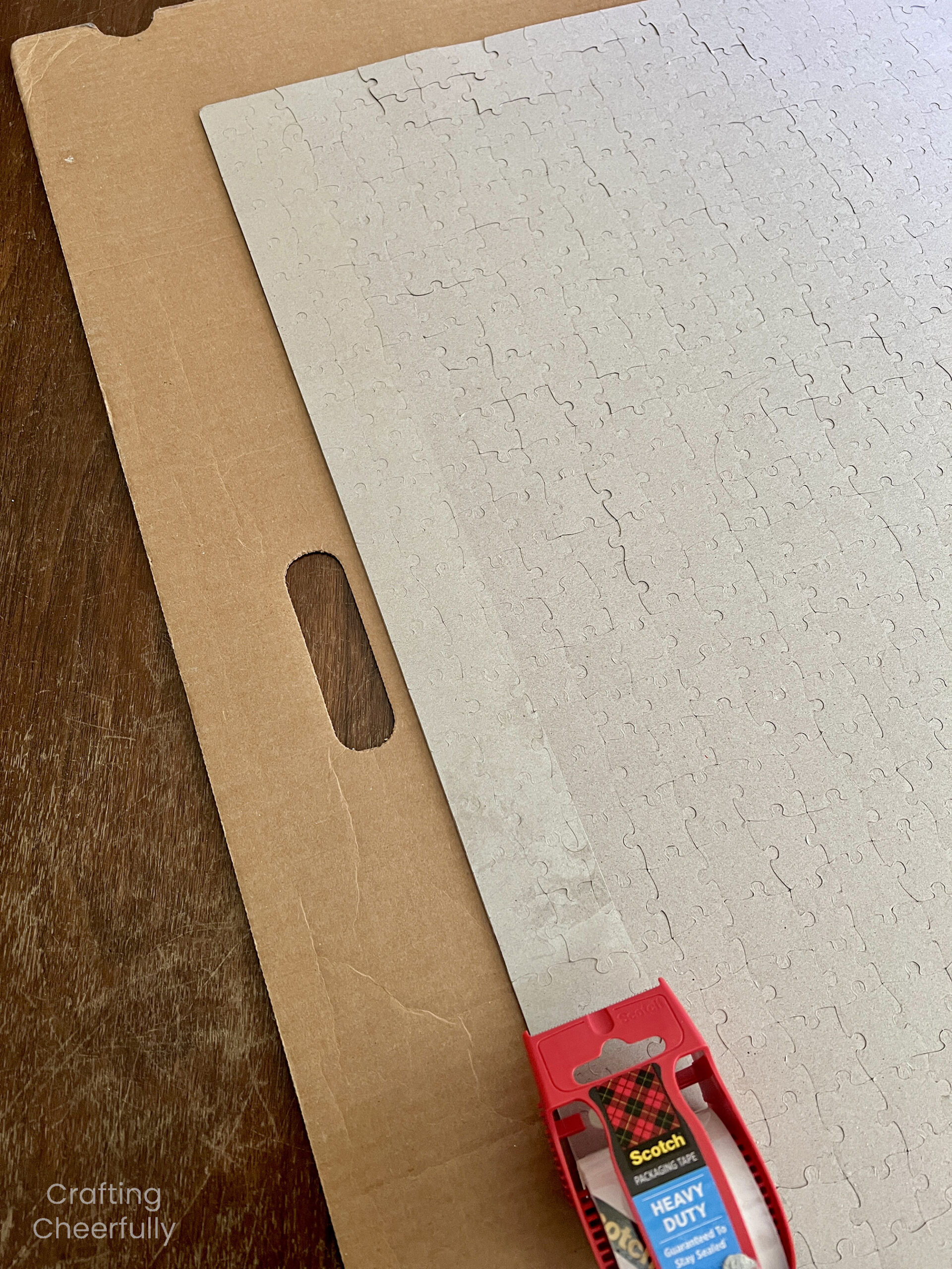 A strip of clear packing tape is applied to the edge of the puzzle.