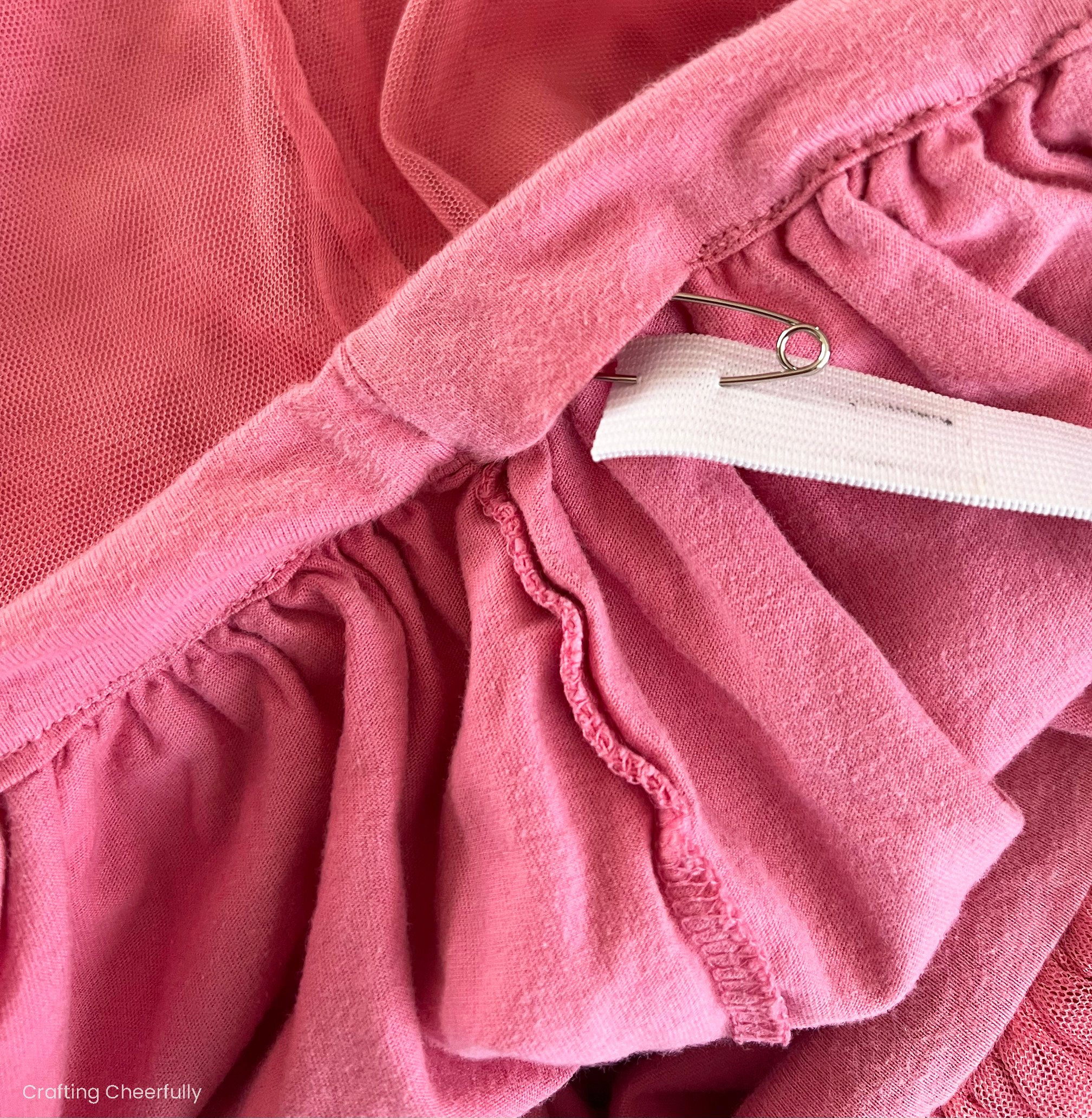 A piece of elastic with a safety pin on the end is pushed through the waistband of the skirt.