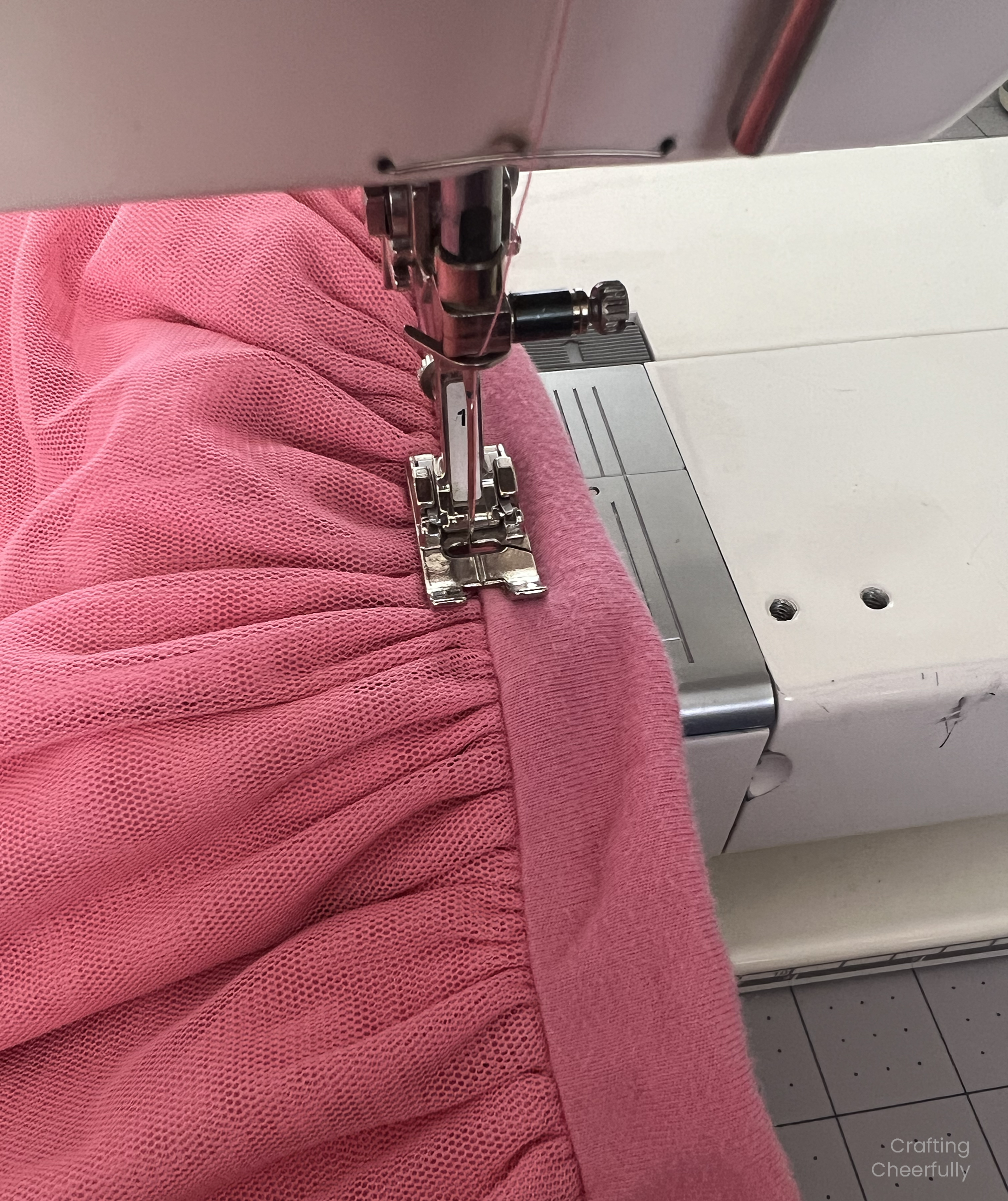 Skirt waistband is being sewn on the machine, the needle is positioned right over the seam line.