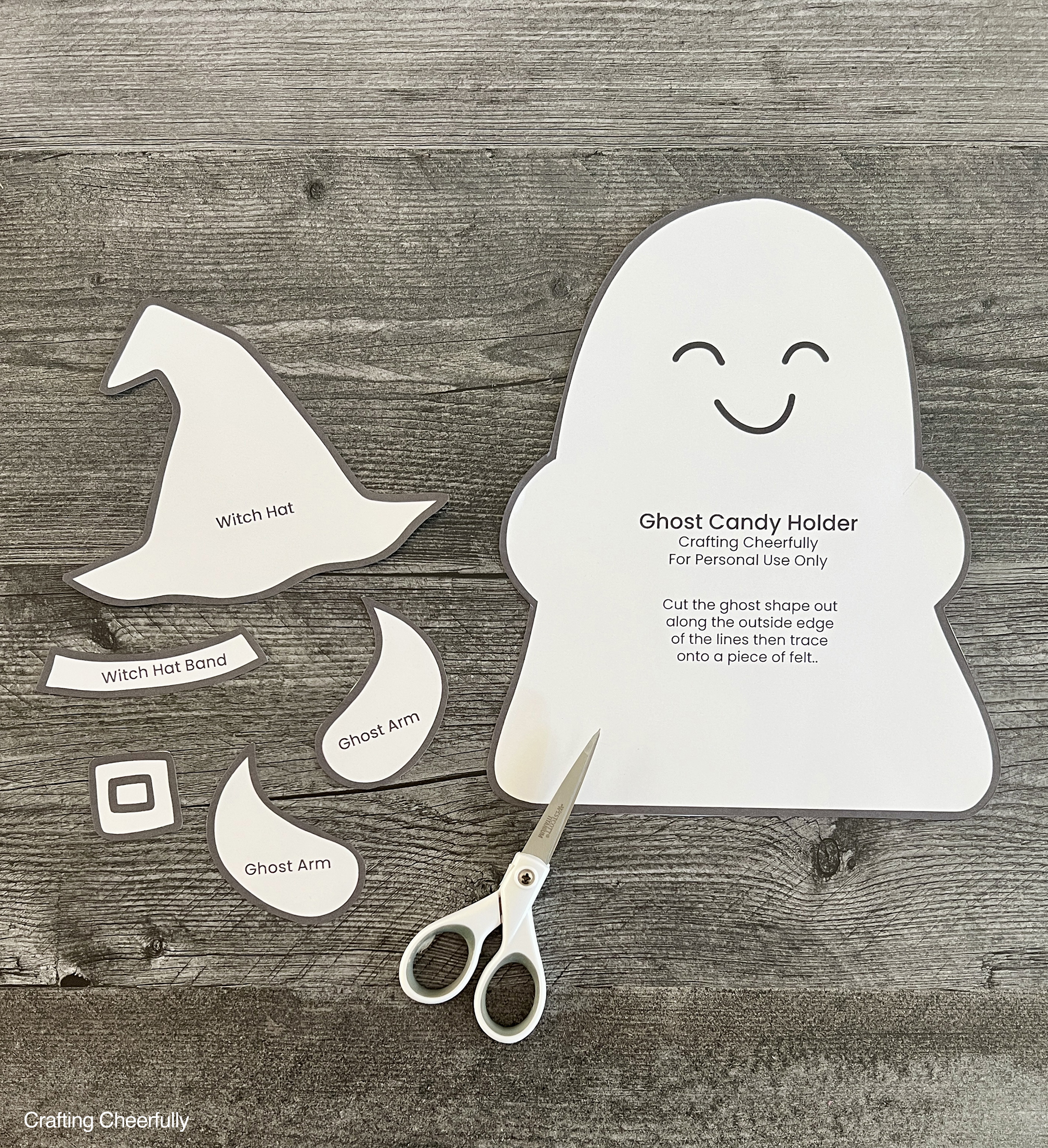 Ghost candy holder pattern pieces are cut out and laying on a wood table.