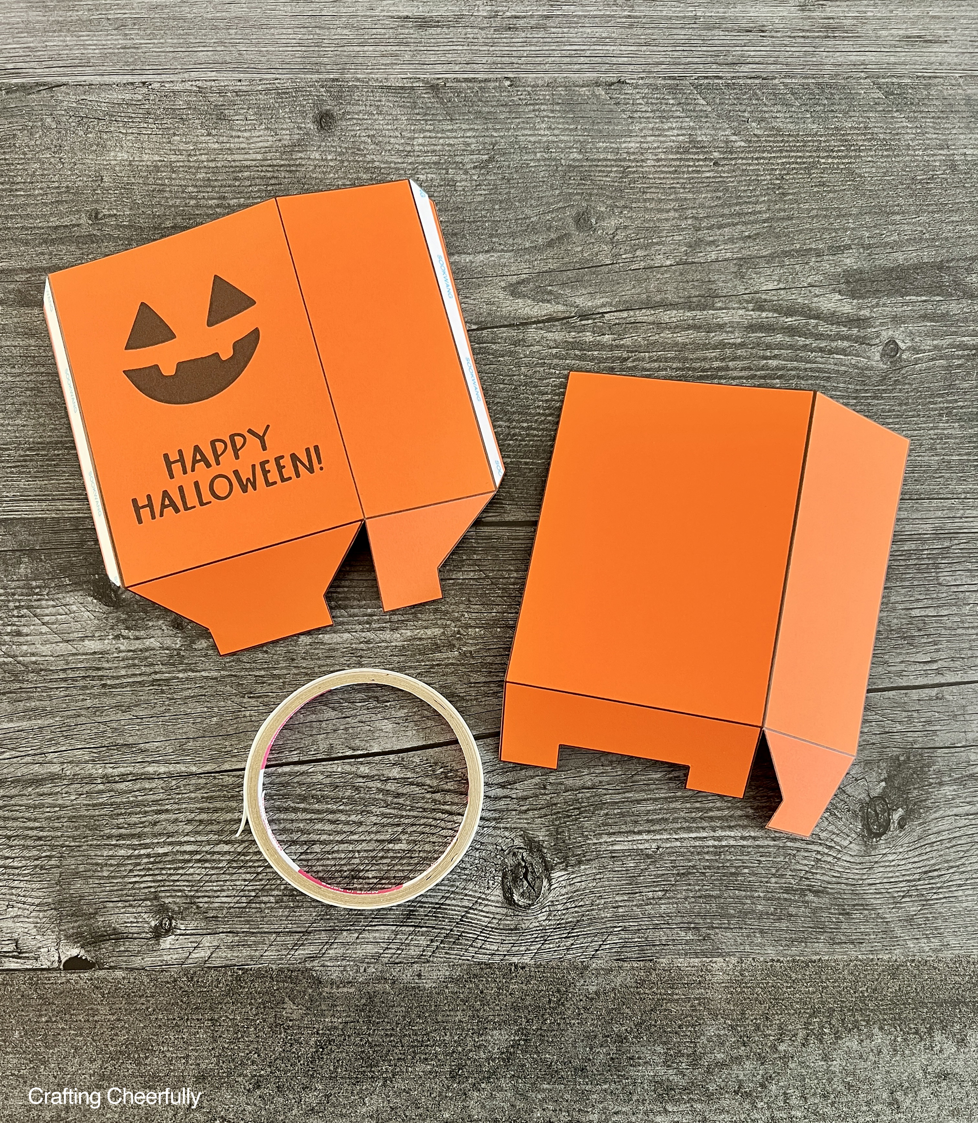 Double-sided tape is applied to the tabs on the box pieces.