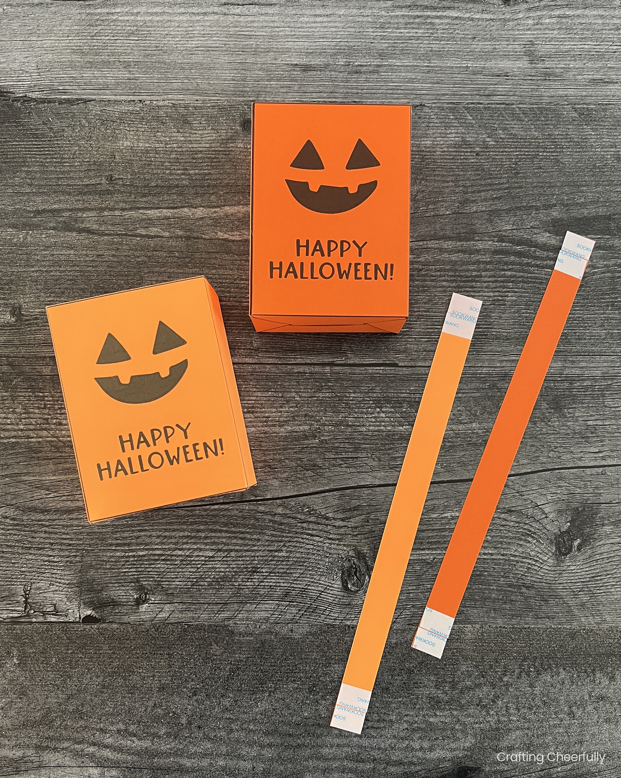 Strips of paper with double-sided tape on the ends lay next to the pumpkin treat boxes.