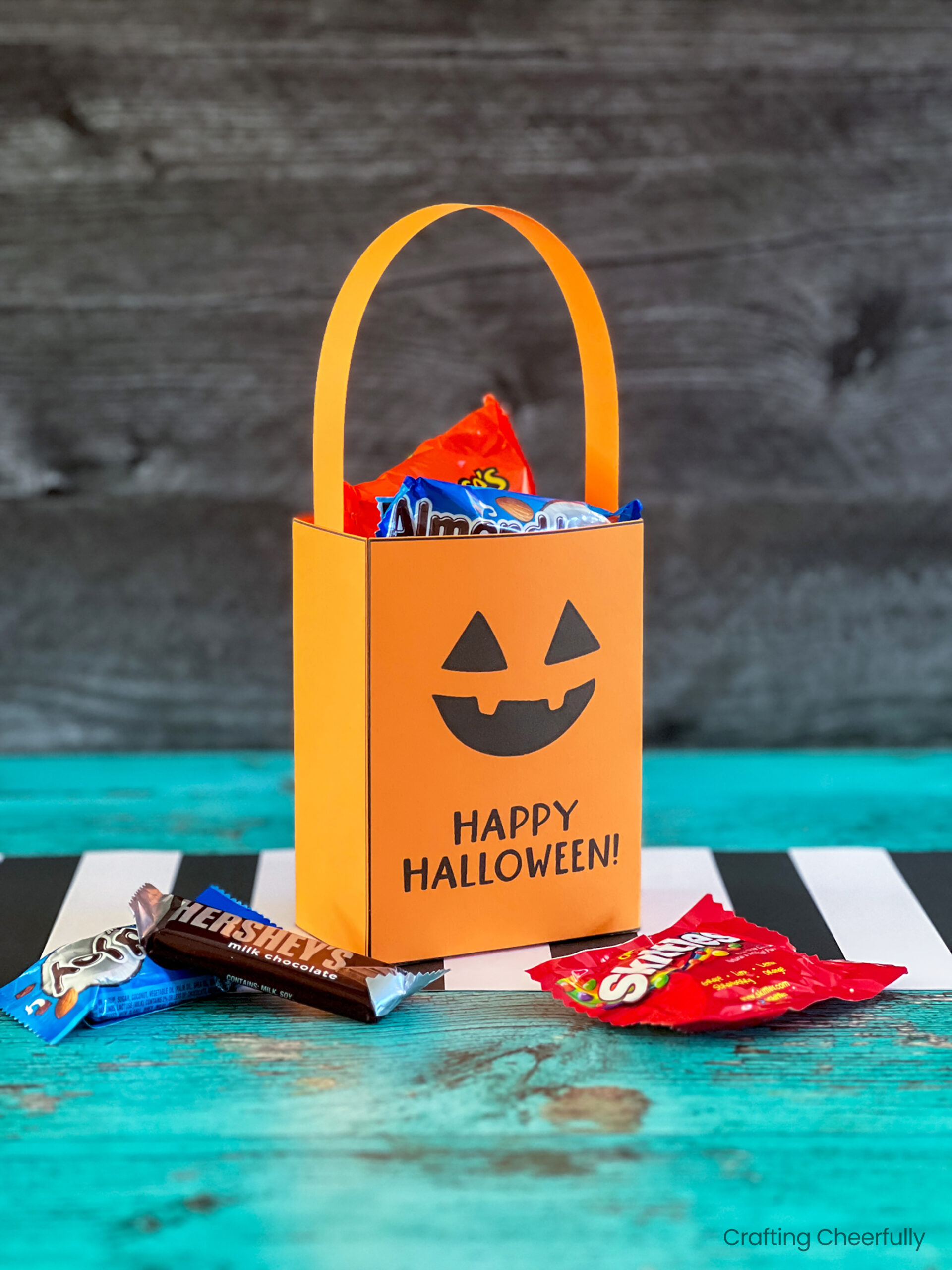 Orange Jack-o'-lantern pumpkin treat box filled with candy.