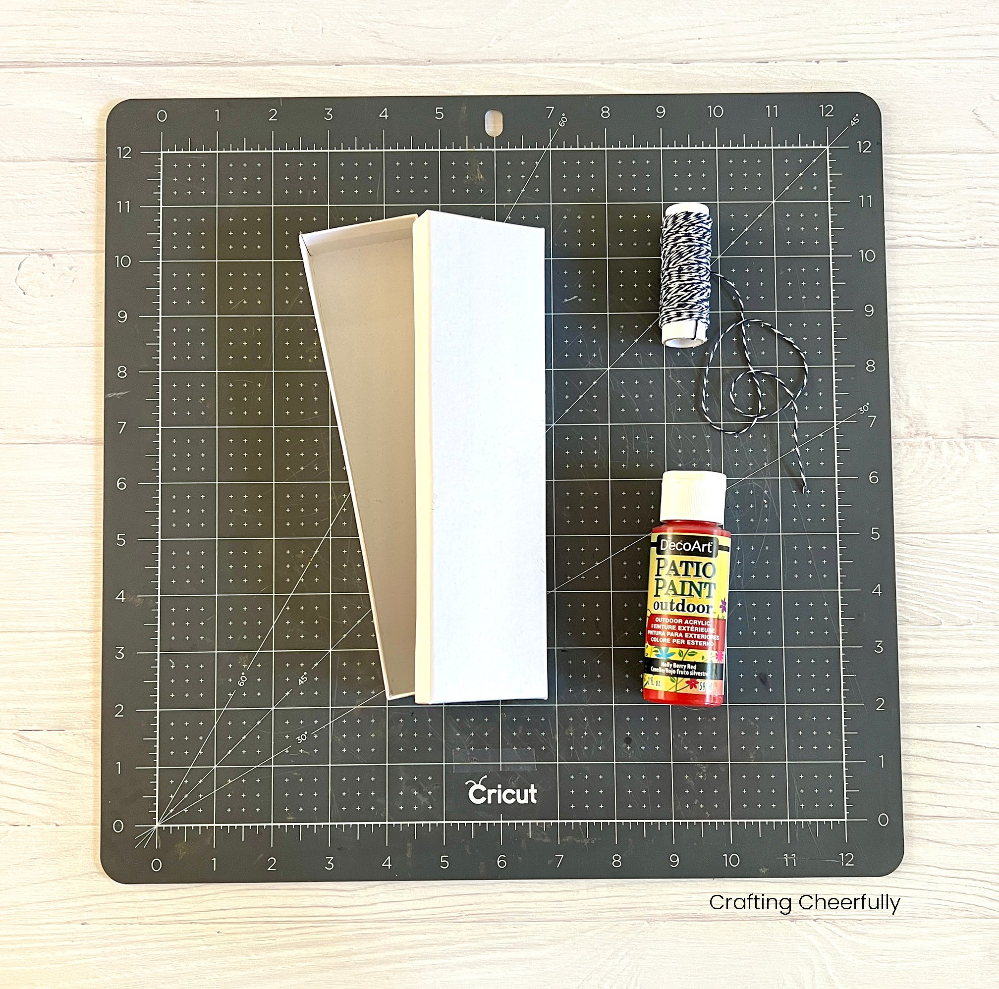 Cutting mat with white box, red paint and Baker's twine.