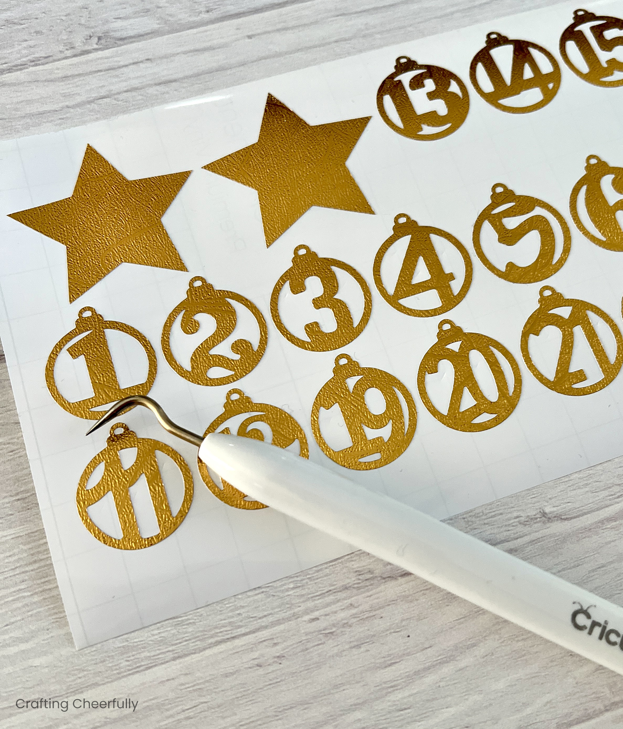 A sheet of gold vinyl with the ornament numbers cut from it and weeded.