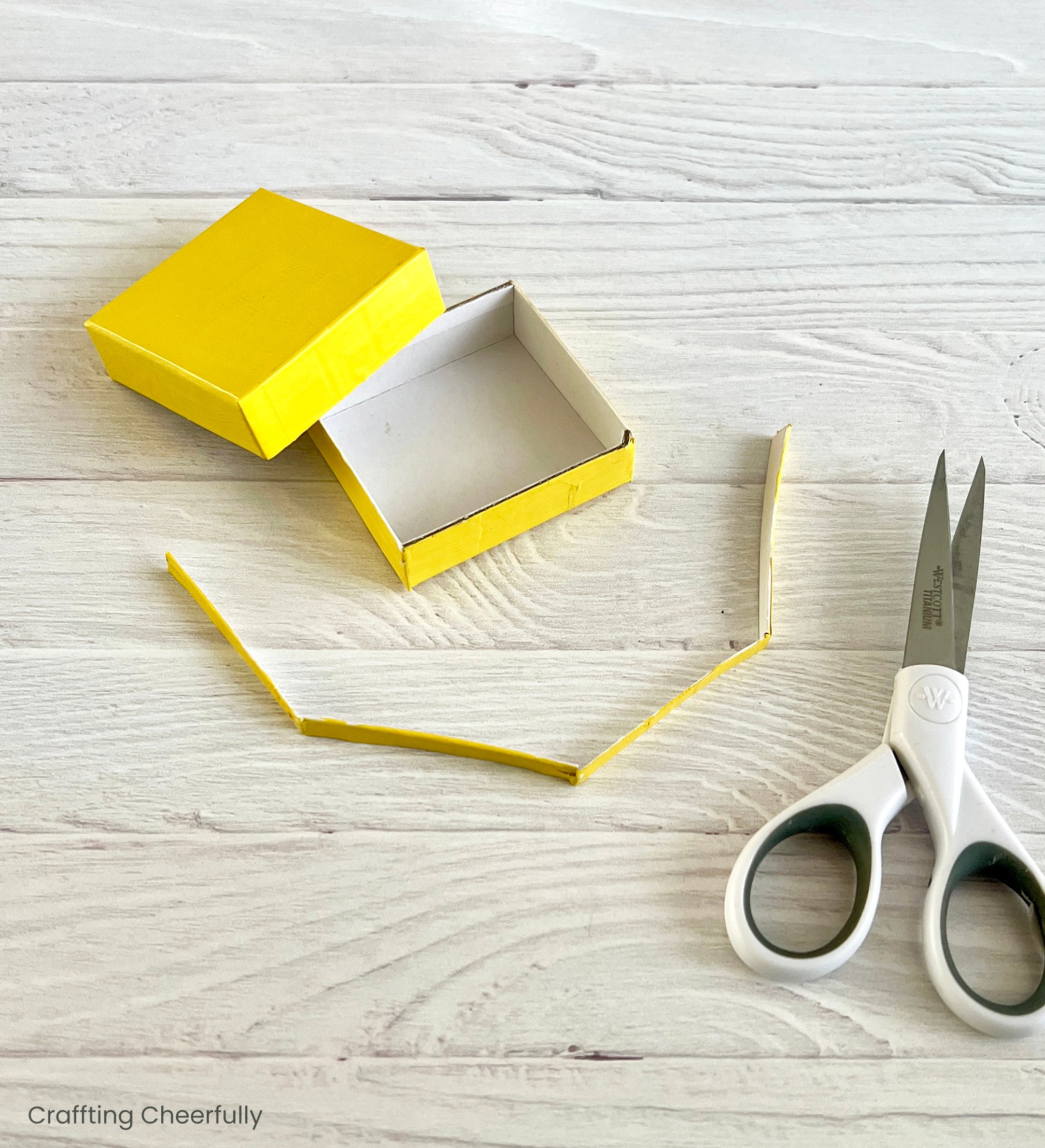 The top edge of the board game ornament base is trimmed off with a scissors.