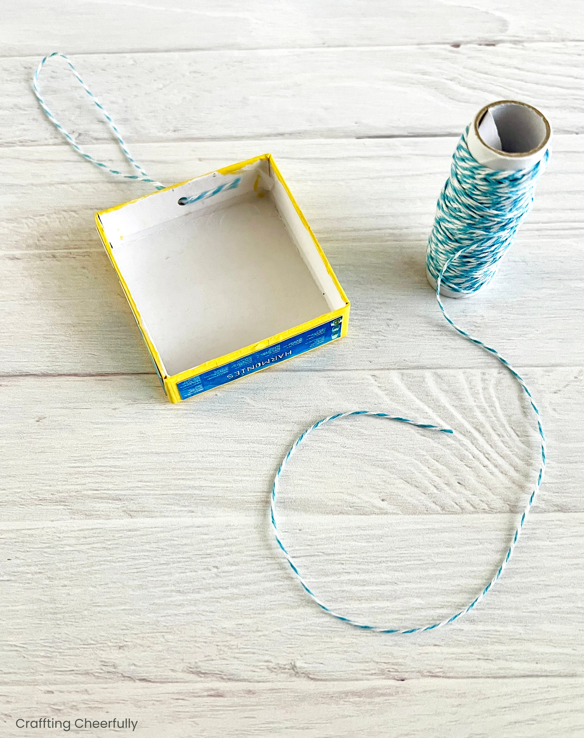 A twine loop is attached to the inside of the box lid.