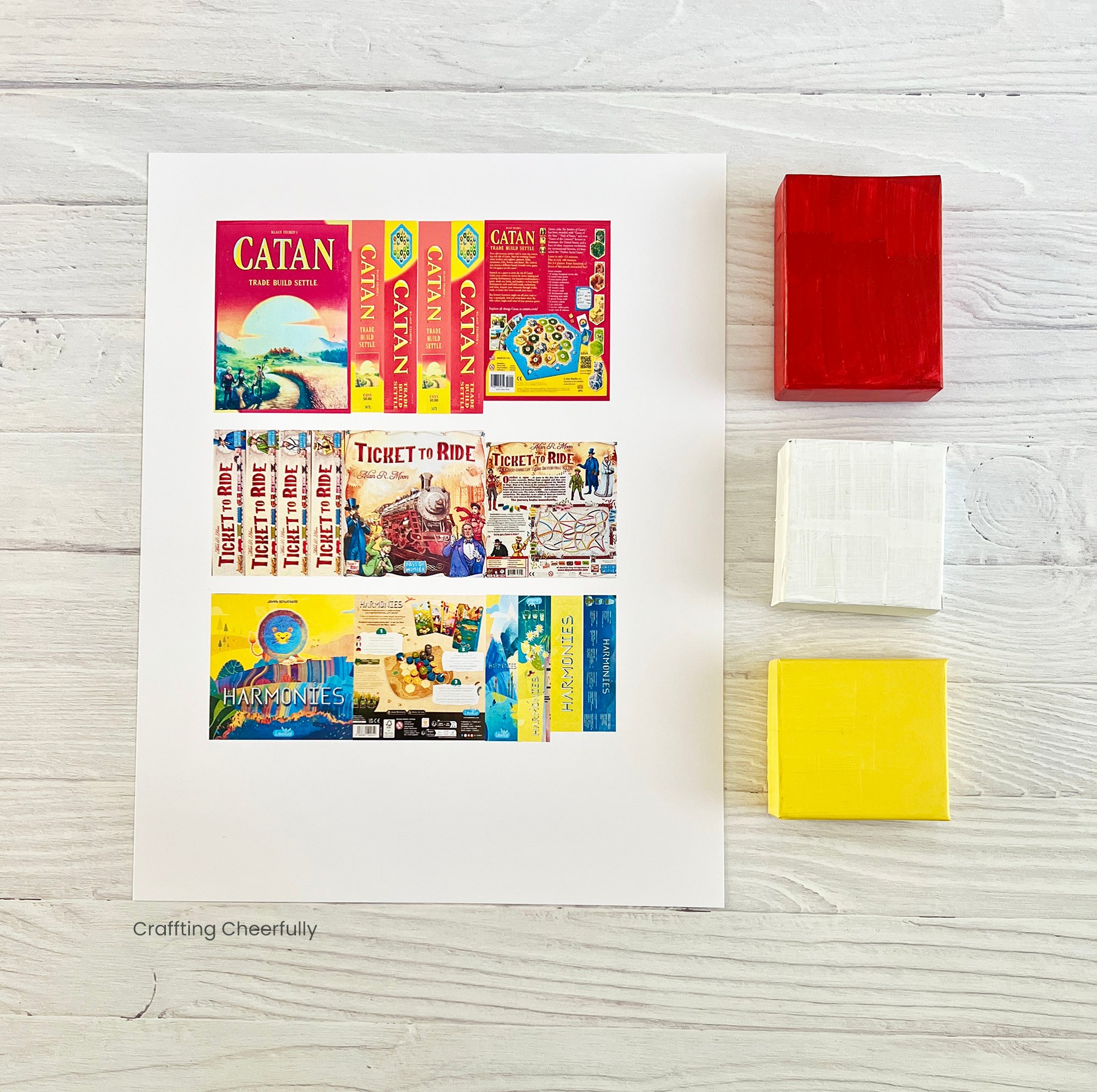 A printable with graphics for the board game ornaments lay next to the painted boxes.