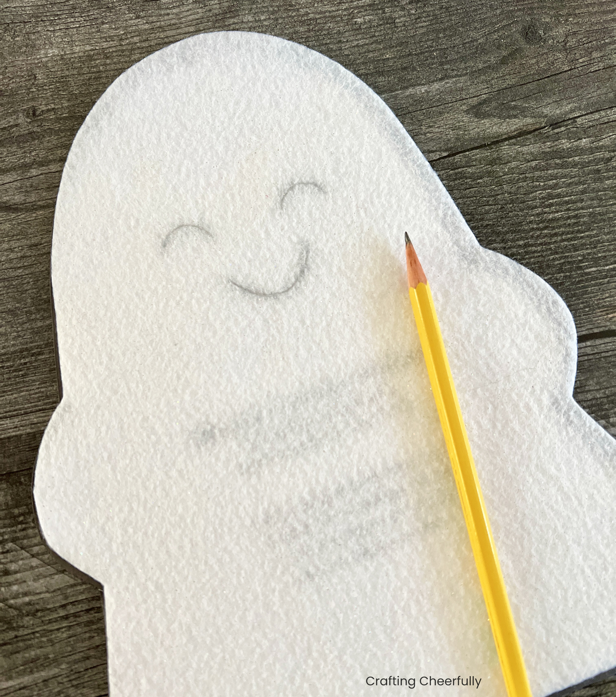 The ghost's face is traced in pencil onto the white felt piece.