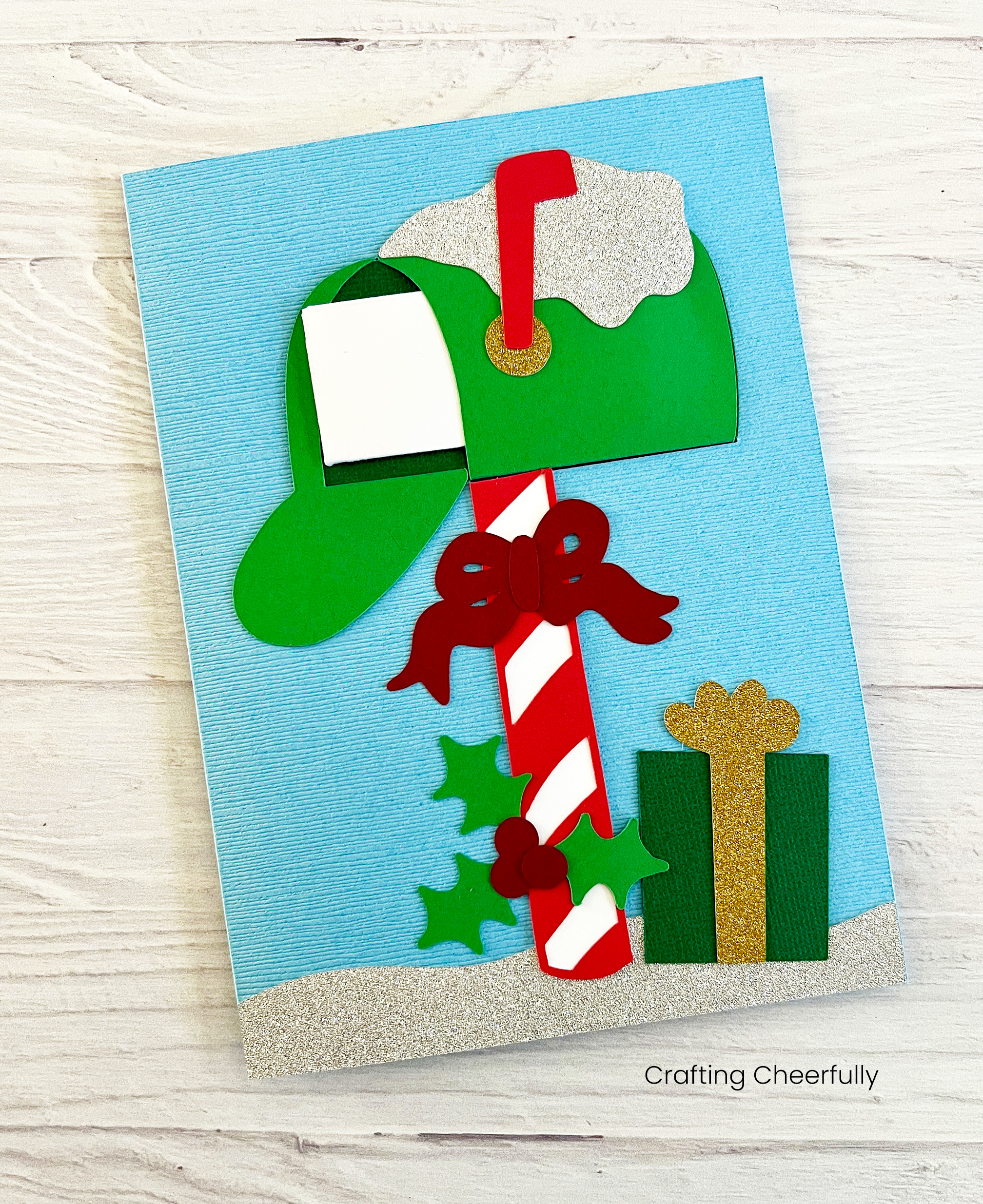 A mini white envelope is slid into the green mailbox on the cover of the card.