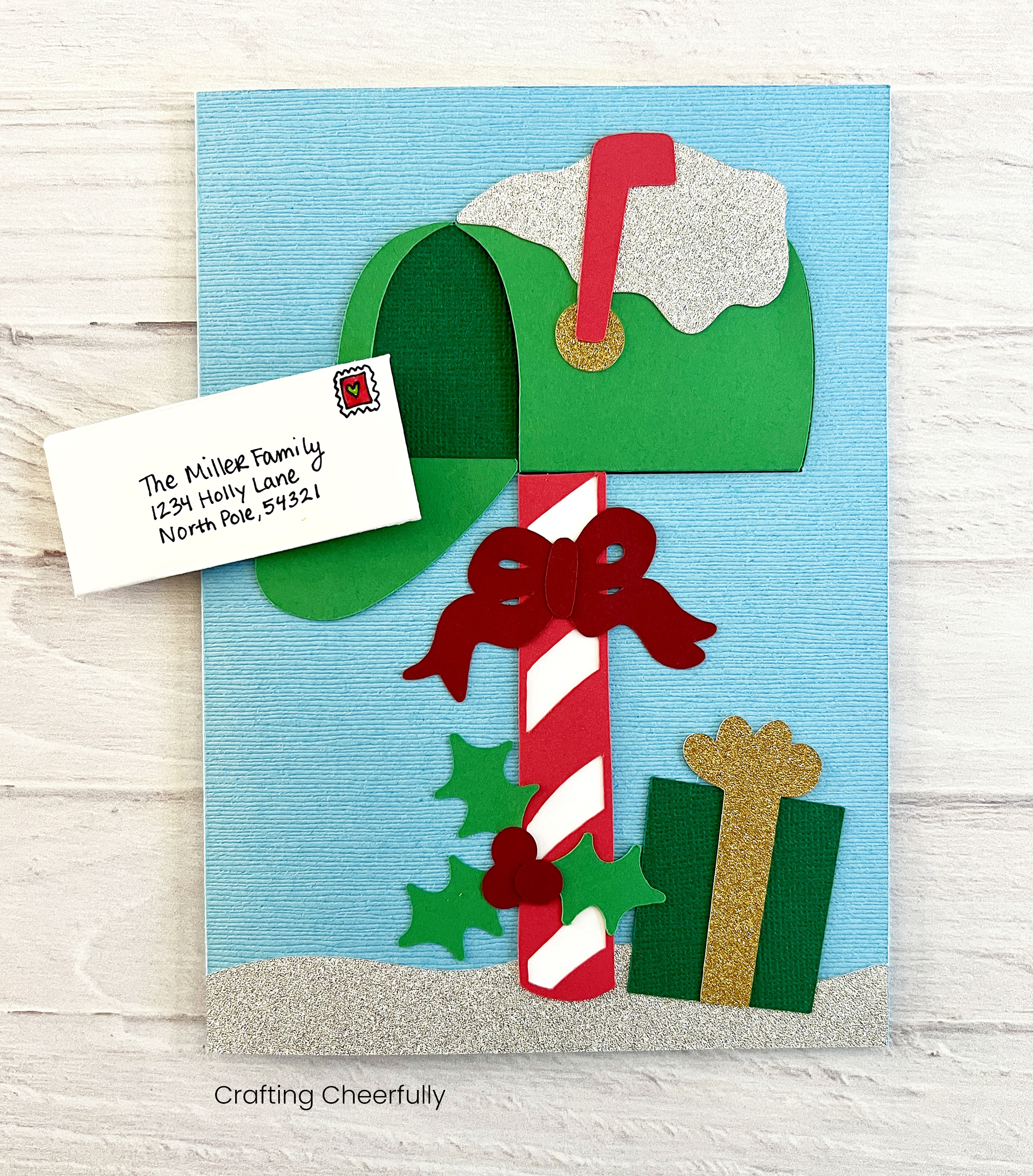 A festive DIY mailbox card with a cute mini letter about to slide into the mailbox.